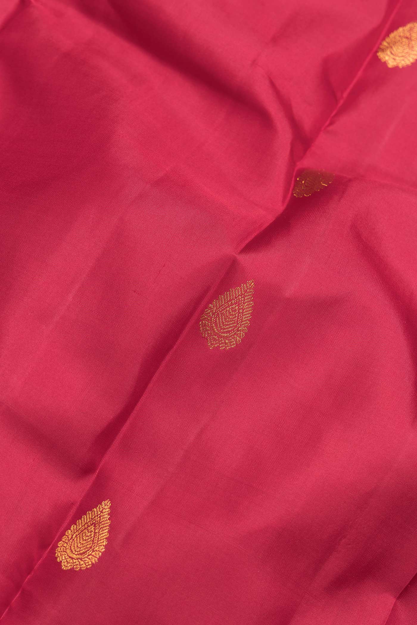 Close up of Maroon Dual Tone Kanchipuram Silk Saree with Zari Butta on the body and Zari Border.  displaying folds