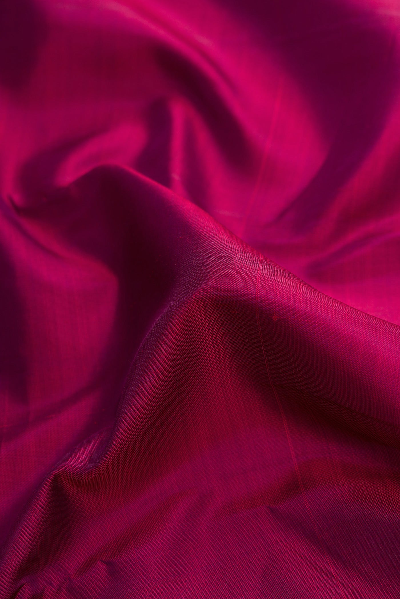 Close up of Burgundy Dual Tone Kanjivaram Silk Saree with Plain Body and Zari Border.  displaying folds