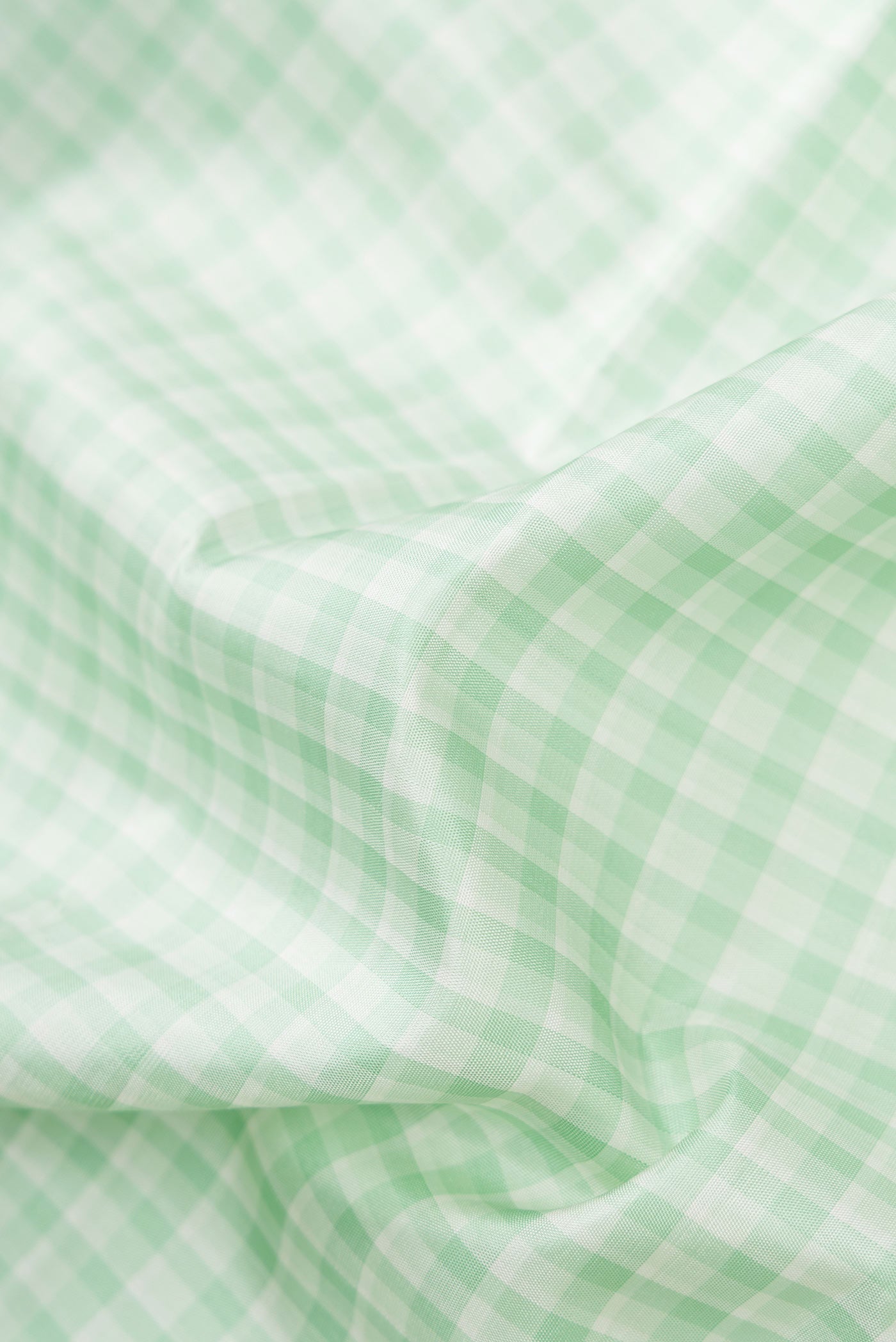 Close up of Pista Green Dual Tone Kanjivaram Silk Saree with Checked design on the body and Zari Border.  displaying folds