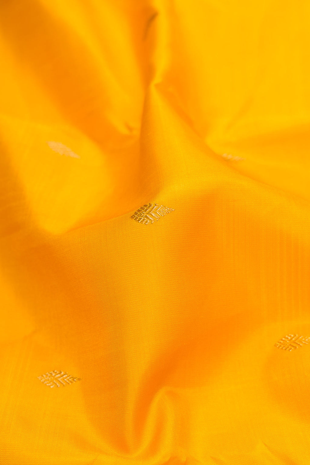 Close up of Pure Silk Pure Zari Mustard Dual Tone Kanchipuram Saree with Zari Butta on the body and Zari And Thread Border displaying folds