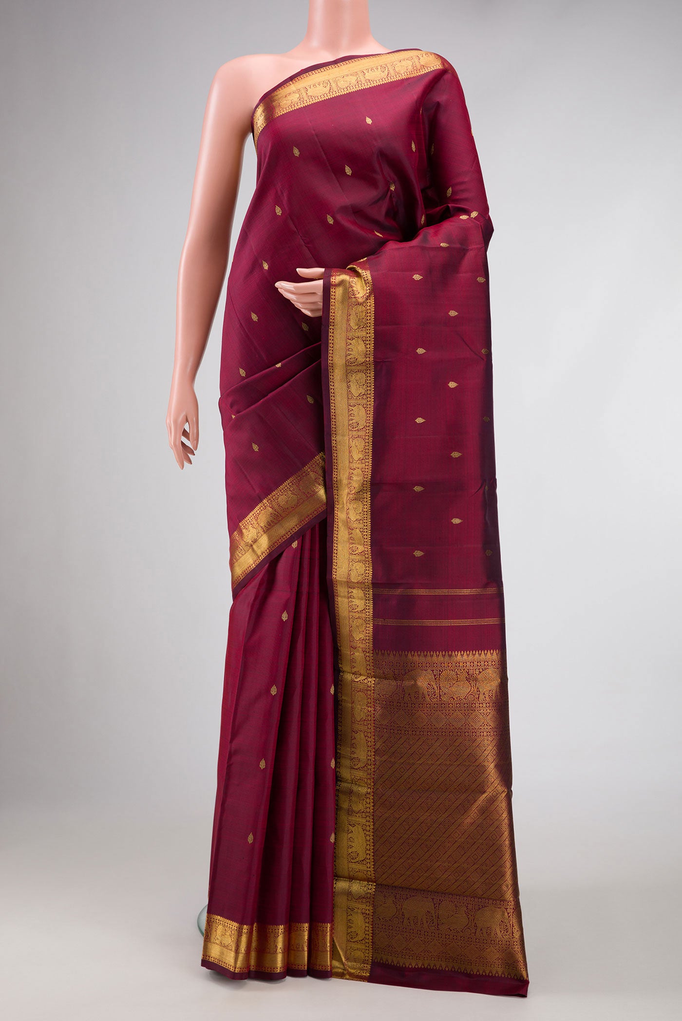 Pure Silk Pure Zari Burgundy Dual Tone Kanchipuram Saree with Zari Butta on the body and Zari Border.  displayed on a mannequin