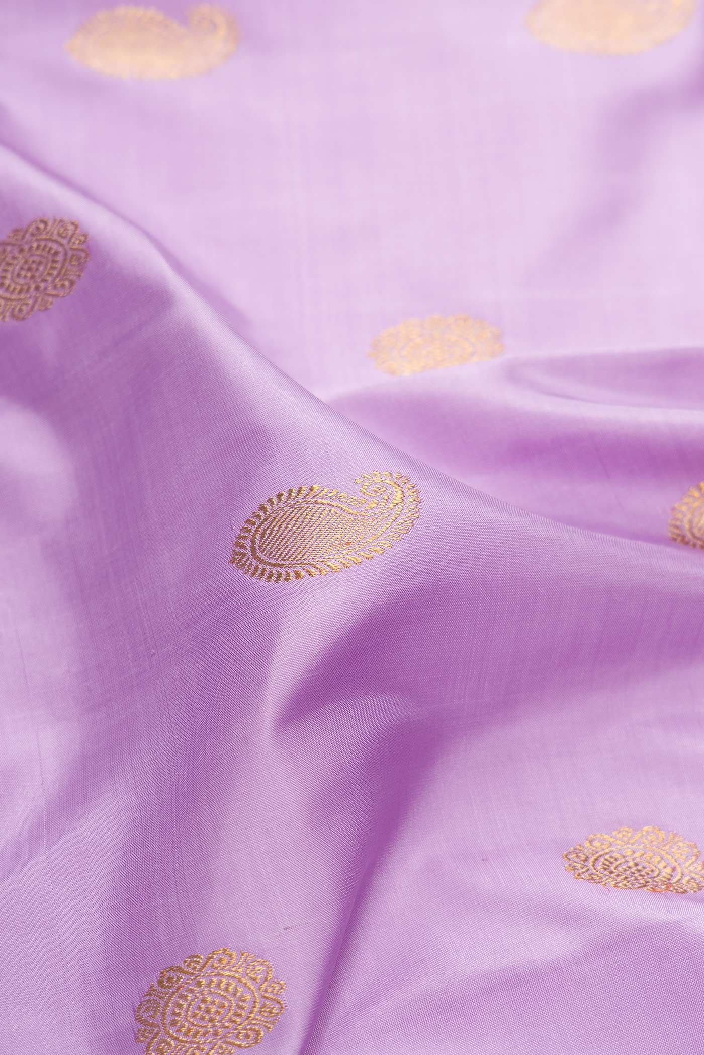 Close up of Pure Silk Pure Zari Lavender Dual Tone Kanchipuram Saree with Zari Butta on the body and Thin Zari Line.  displaying folds