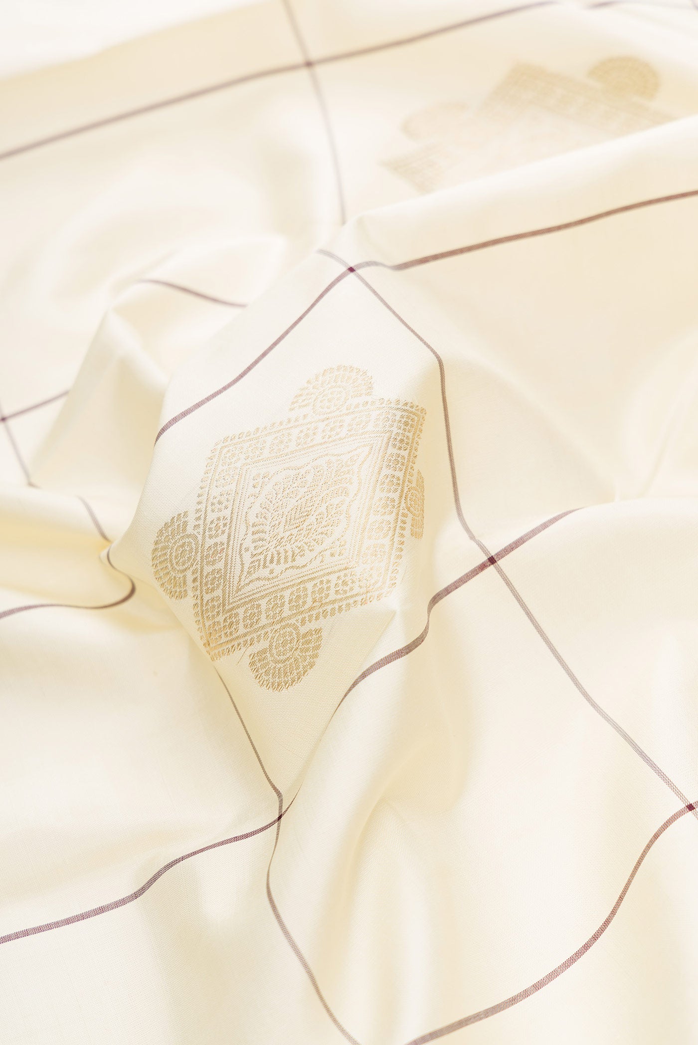 Close up of Pure Silk Pure Zari Off White Dual Tone Kanjivaram Saree with Checked design on the body and Without Border.  displaying folds