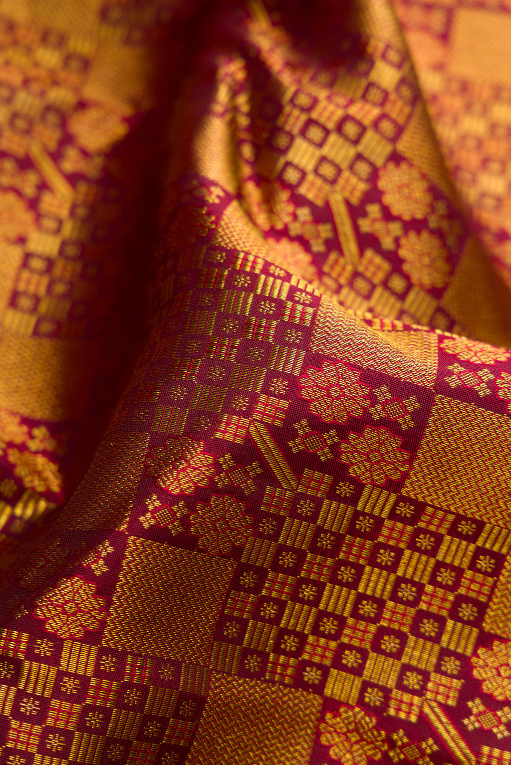 Close up of Maroon Dual Tone Kanjivaram Silk Saree with Zari Brocade on the body and Zari Border.  displaying folds