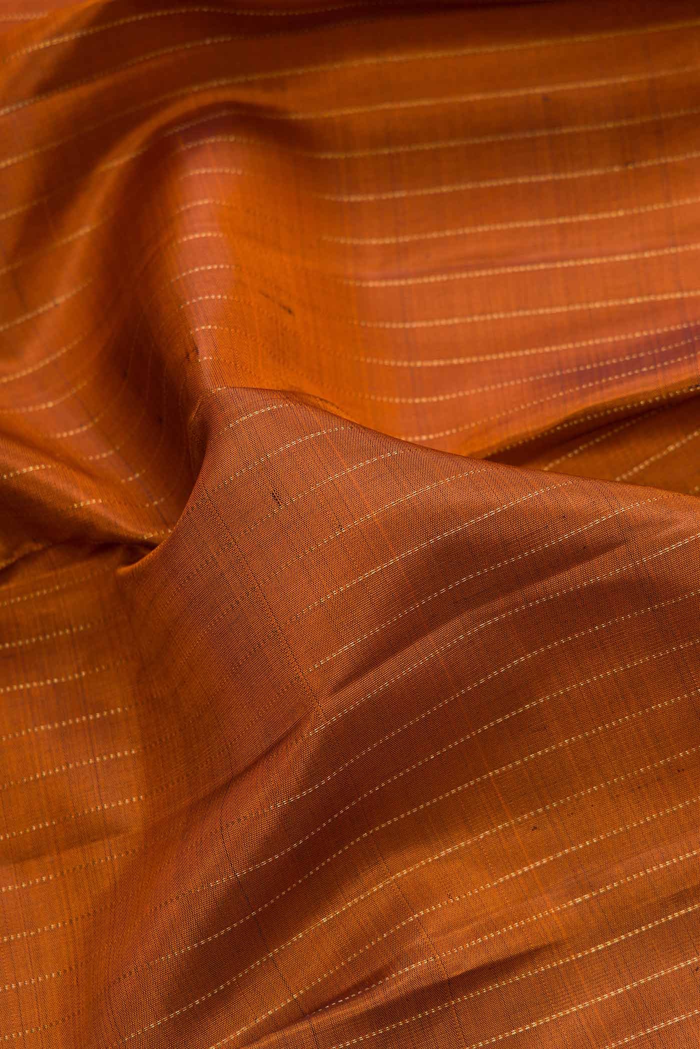Close up of Orange Dual Tone Kanjivaram Silk Saree with Stripes on the body and Zari Border.  displaying folds