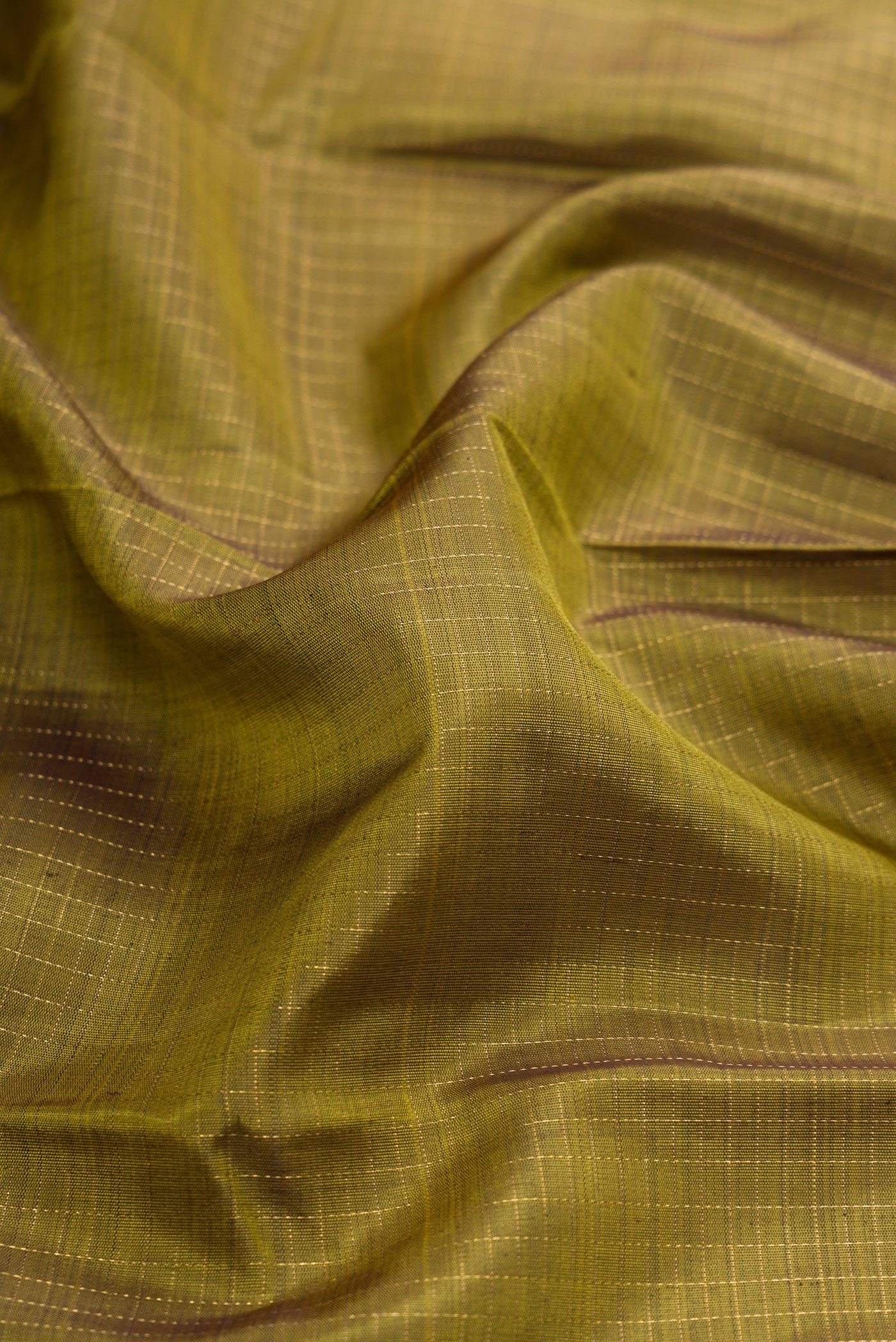 Close up of Green Dual Tone Kanchipuram Silk Saree with Zari Butta on the body and Zari Border.  displaying folds