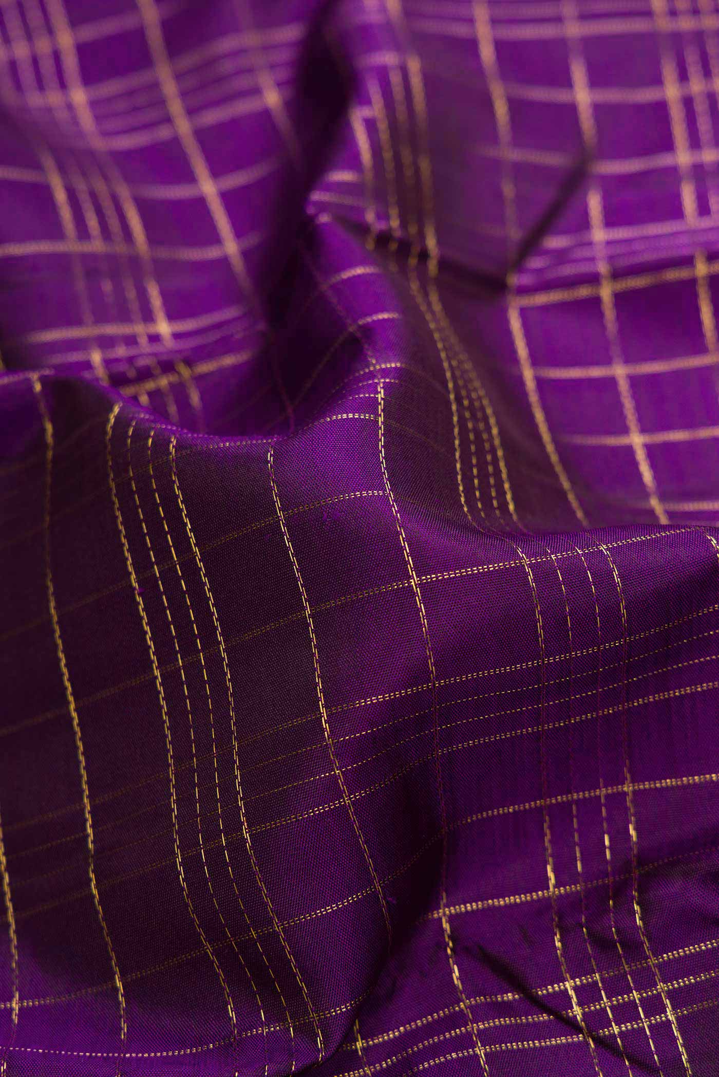 Close up of Pure Silk Pure Zari Violet Dual Tone Kanchipuram Saree with Checked design on the body and Zari Border.  displaying folds