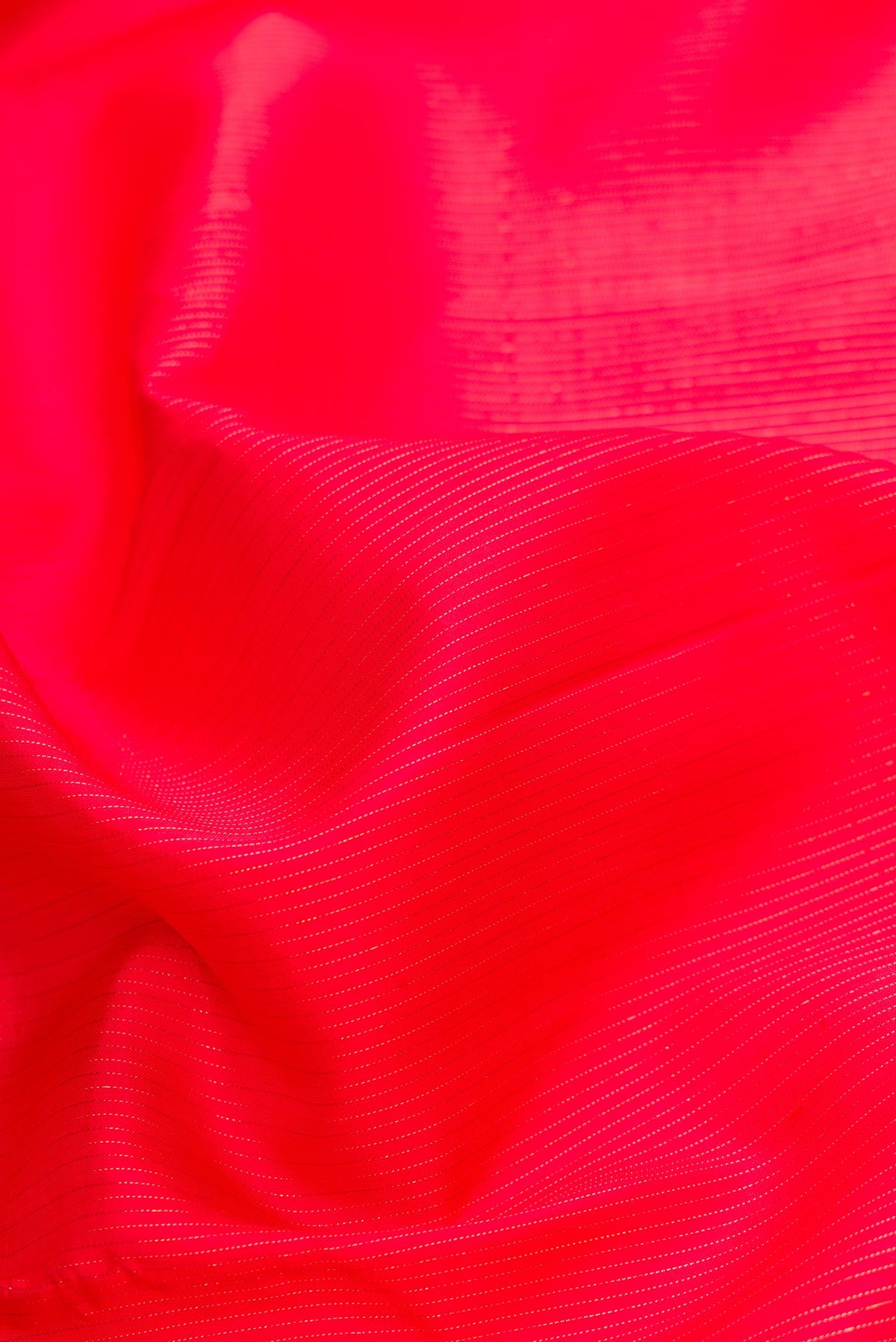 Close up of Pure Silk Pure Zari Red Dual Tone Kanjivaram Saree with Stripes on the body and Without Border.  displaying folds
