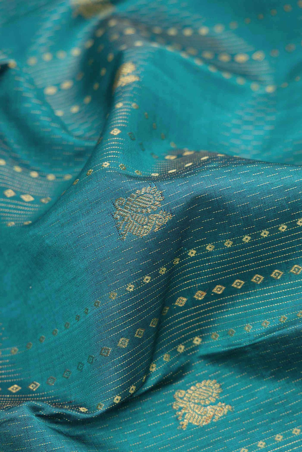 Close up of Maya Blue Dual Tone Kanchipuram Silk Saree with Zari Butta on the body and Zari Border displaying folds