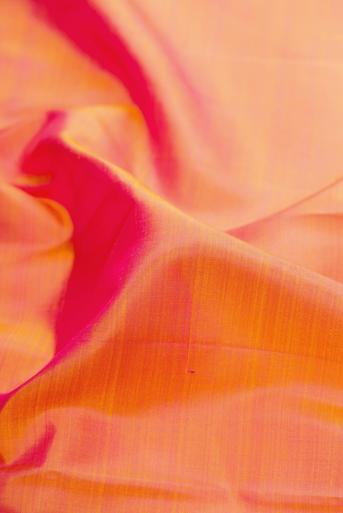 Close up of Orange Dual Tone Kanchipuram Silk Saree with Plain Body and Temple Border.  displaying folds