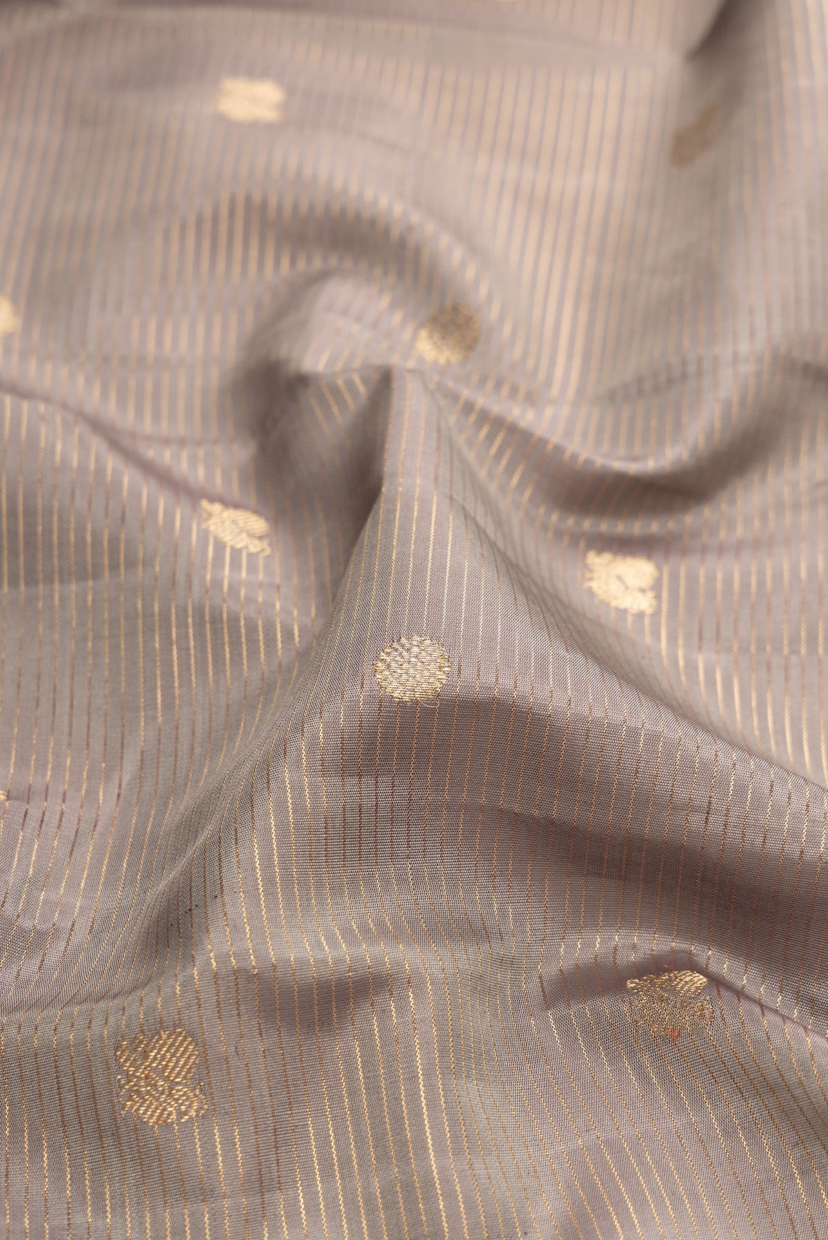Close up of Grey Dual Tone Kanjivaram Silk Saree with Zari Butta on the body and Zari Border.  displaying folds