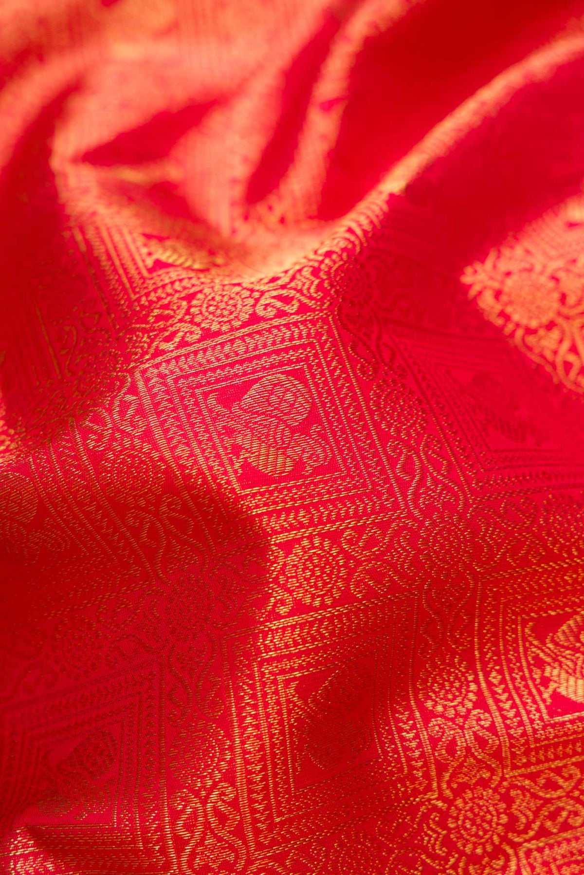 Close up of Pure Silk Pure Zari Red Dual Tone Kanchipuram Saree with Zari Brocade on the body and Zari Border displaying folds