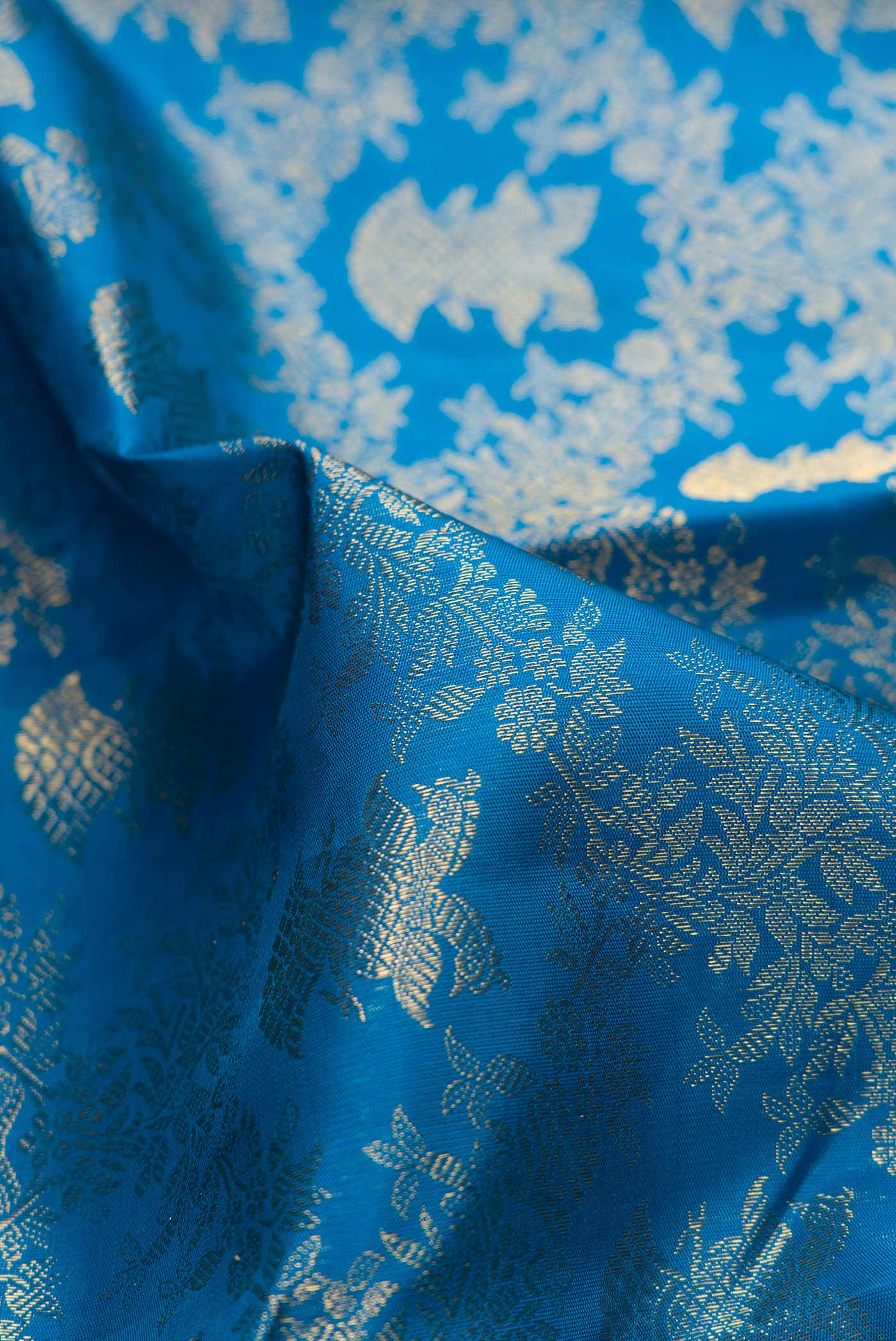 Close up of Pure Silk Pure Zari Peacock Blue Dual Tone Kanchipuram Saree with Zari Brocade on the body and Zari Border displaying folds