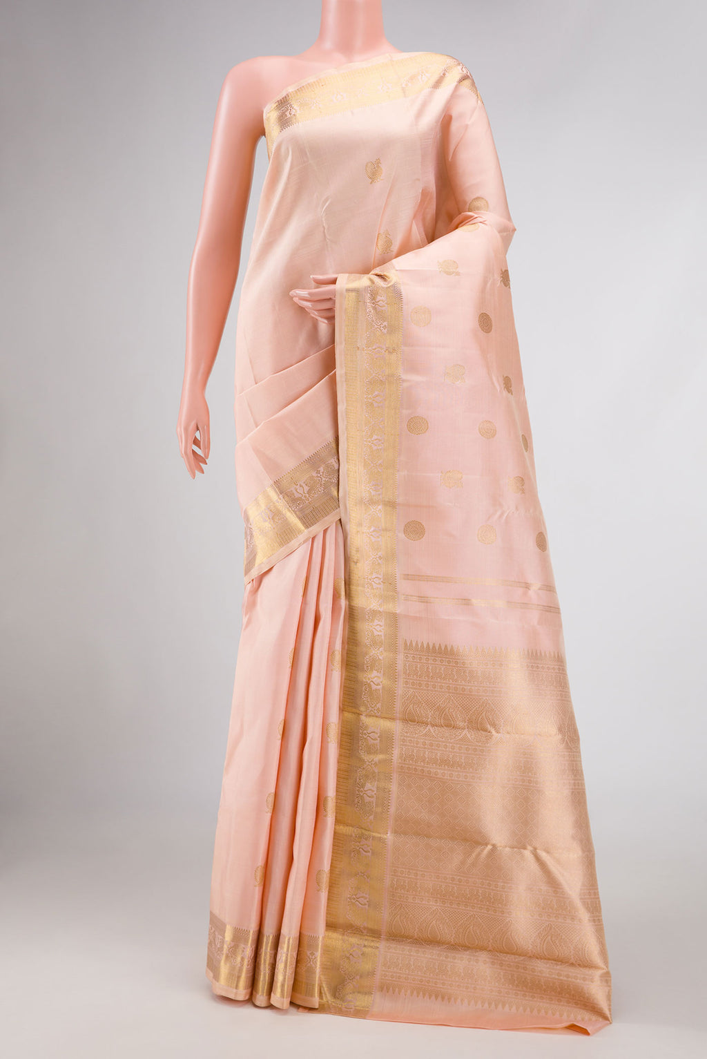 Pure Silk Pure Zari Rose Gold Dual Tone Kanjivaram Saree with Zari Butta on the body and Zari Border.  displayed on a mannequin