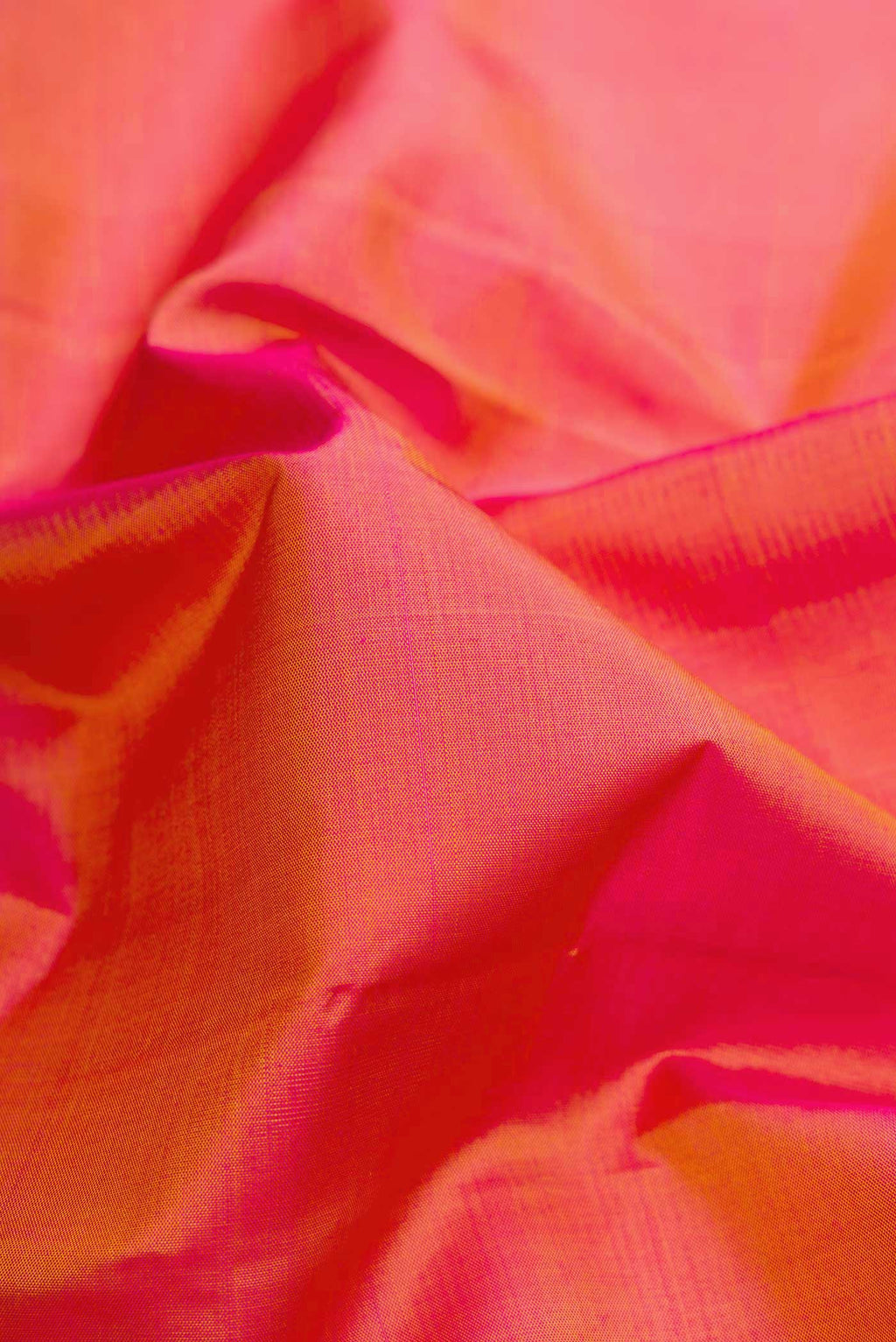 Close up of Coral Dual Tone Kanjivaram Silk Saree with Plain Body and Zari Border.  displaying folds