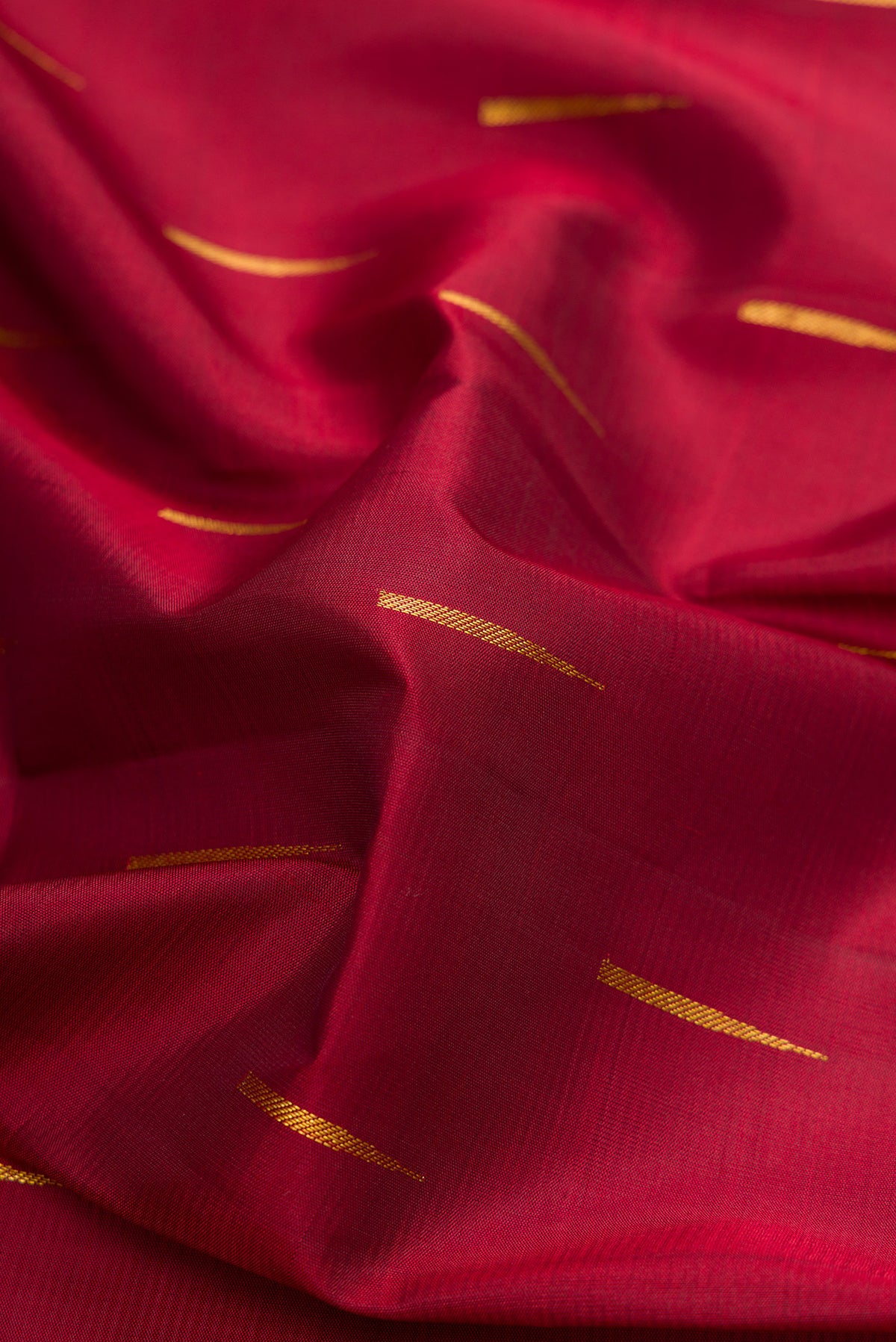 Close up of Maroon Dual Tone Kanchipuram Silk Saree with Zari Butta on the body and Zari Border.  displaying folds