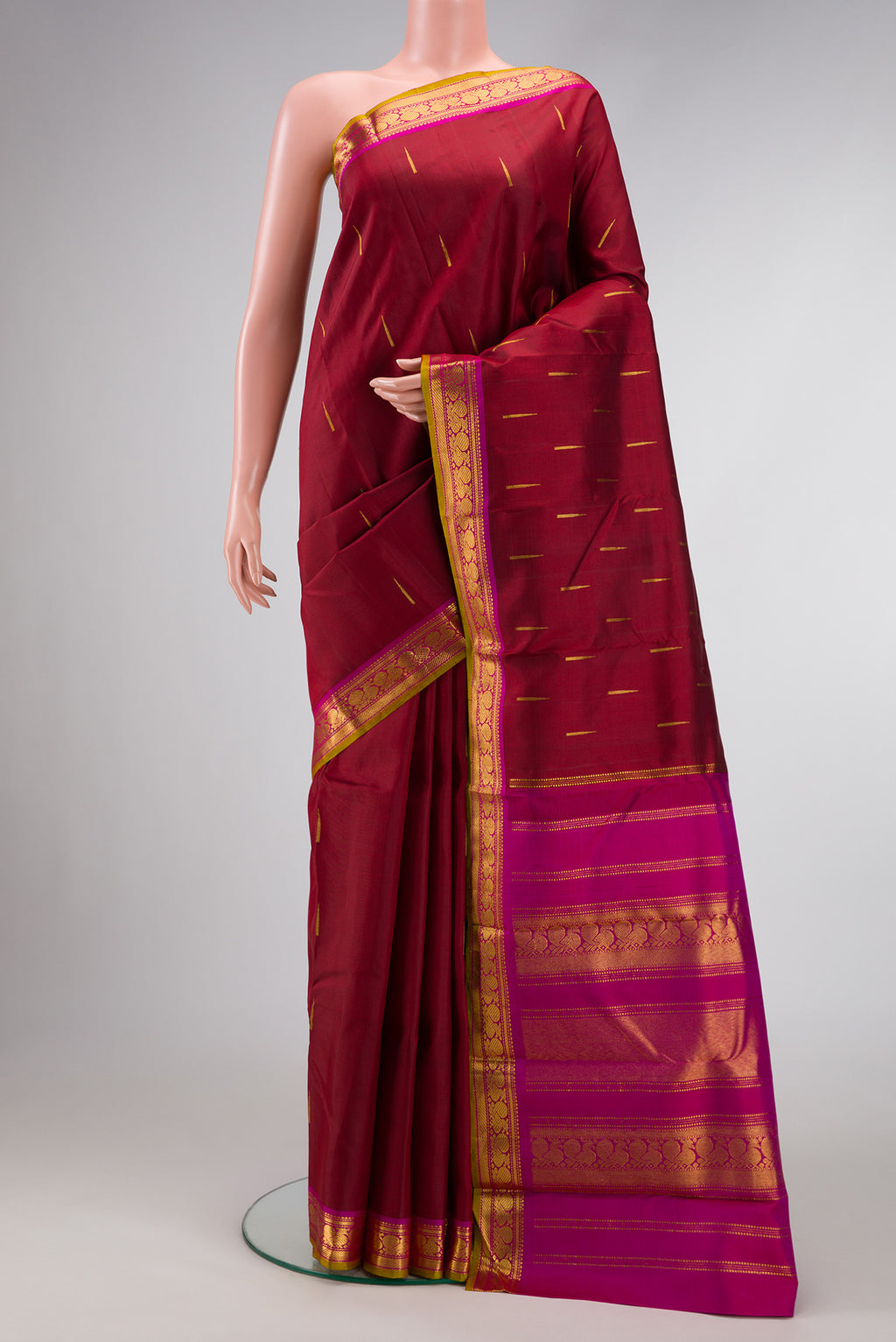 Maroon Dual Tone Kanchipuram Silk Saree with Zari Butta on the body and Zari Border.  displayed on a mannequin