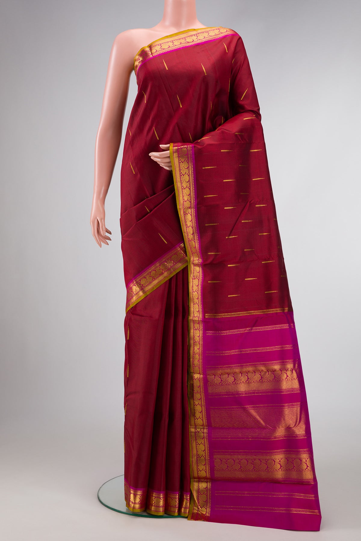 Maroon Dual Tone Kanchipuram Silk Saree with Zari Butta on the body and Zari Border.  displayed on a mannequin