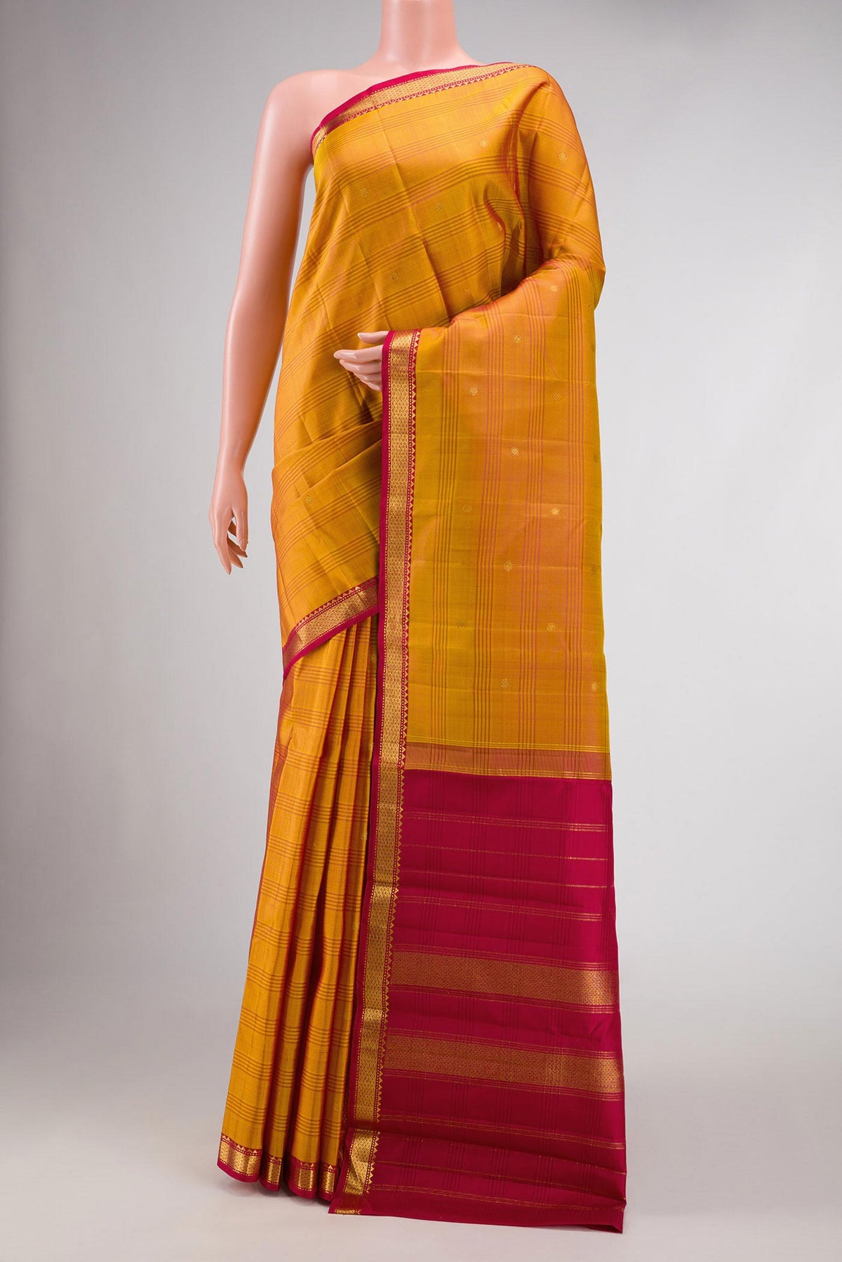 Mustard Dual Tone Kanchipuram Silk Saree with Zari Butta on the body and Zari Border.  displayed on a mannequin