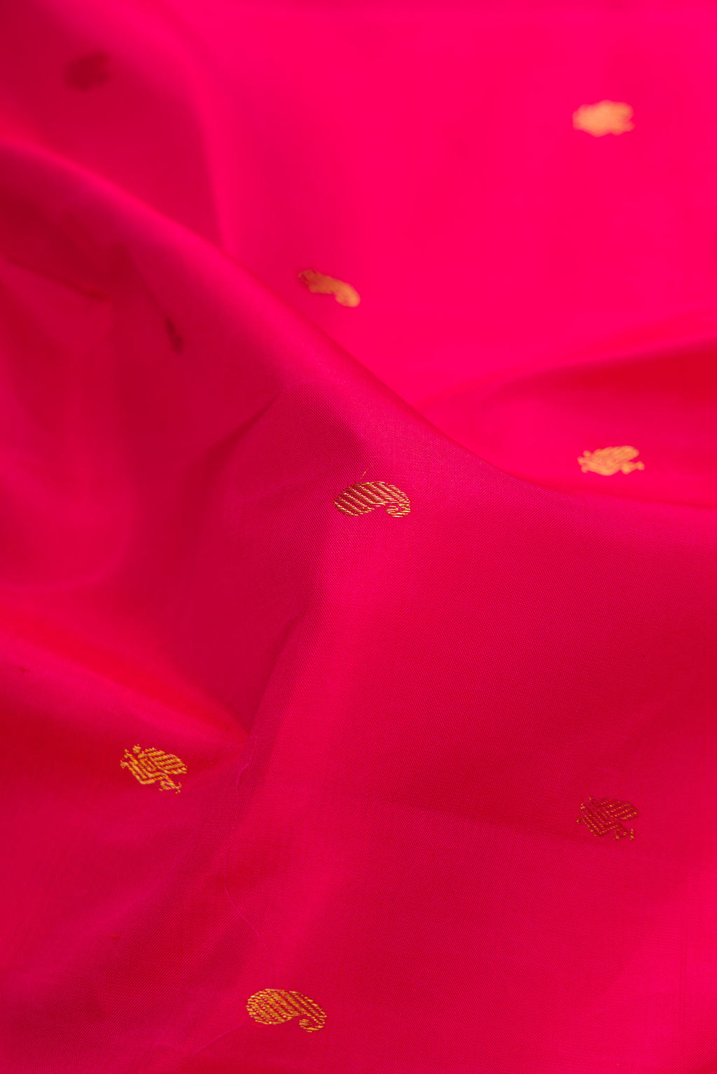 Close up of Pink Dual Tone Kanchipuram Silk Saree with Zari Butta on the body and Zari Border.  displaying folds