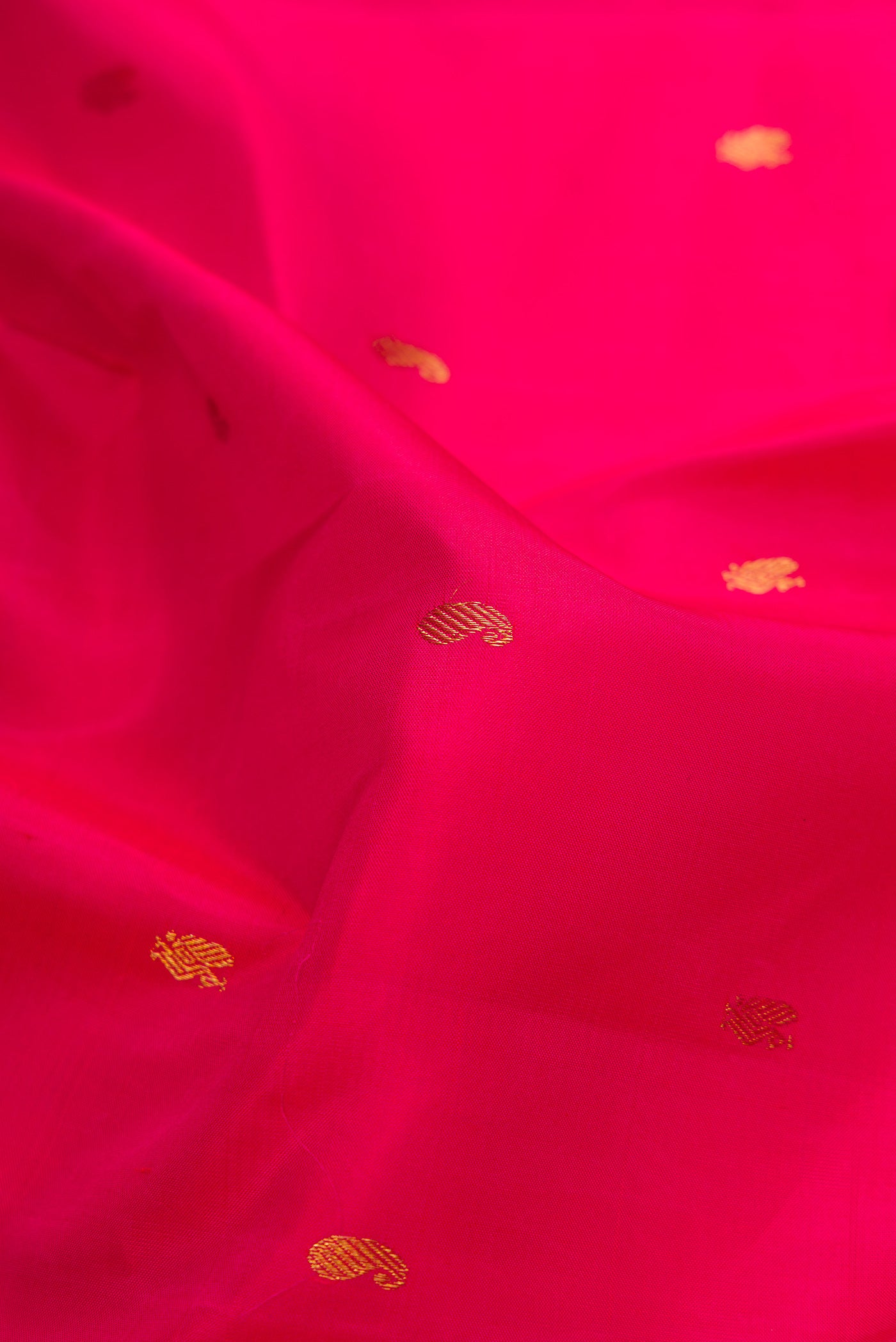 Close up of Pink Dual Tone Kanchipuram Silk Saree with Zari Butta on the body and Zari Border.  displaying folds