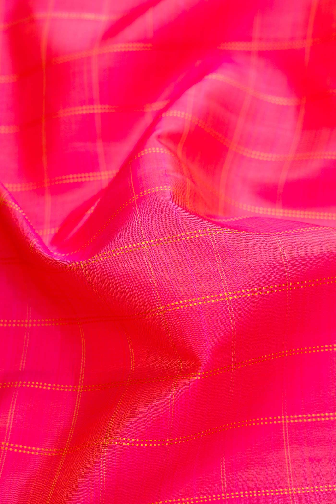 Close up of Orange Dual Tone Kanchipuram Silk Saree with Checked design on the body and Zari Border.  displaying folds