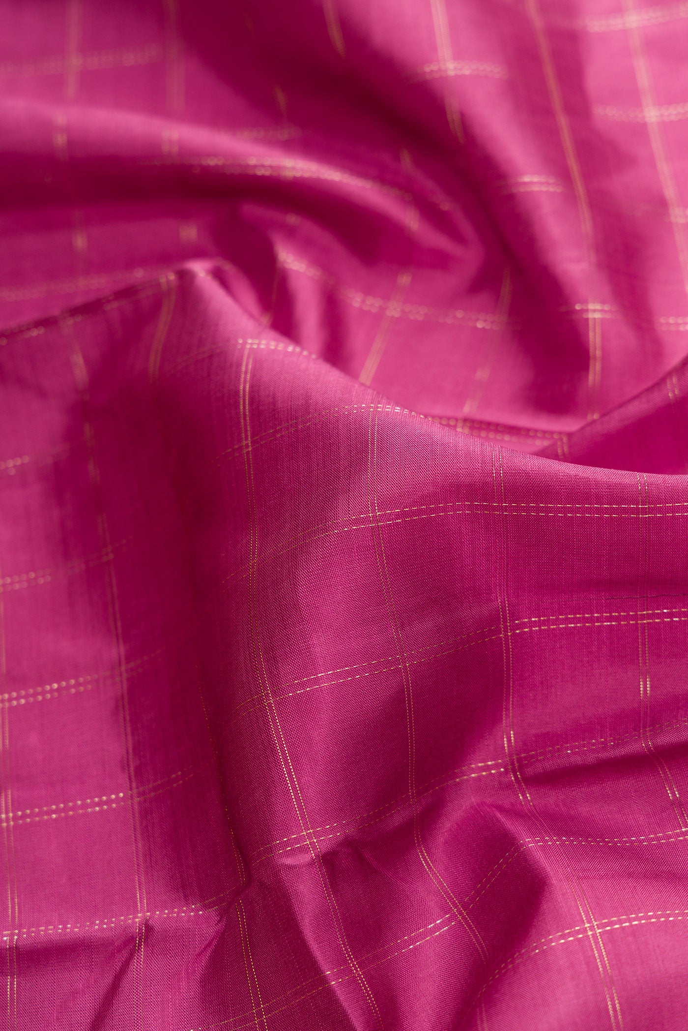 Close up of Pink Dual Tone Kanchipuram Silk Saree with Checked design on the body and Zari Border.  displaying folds