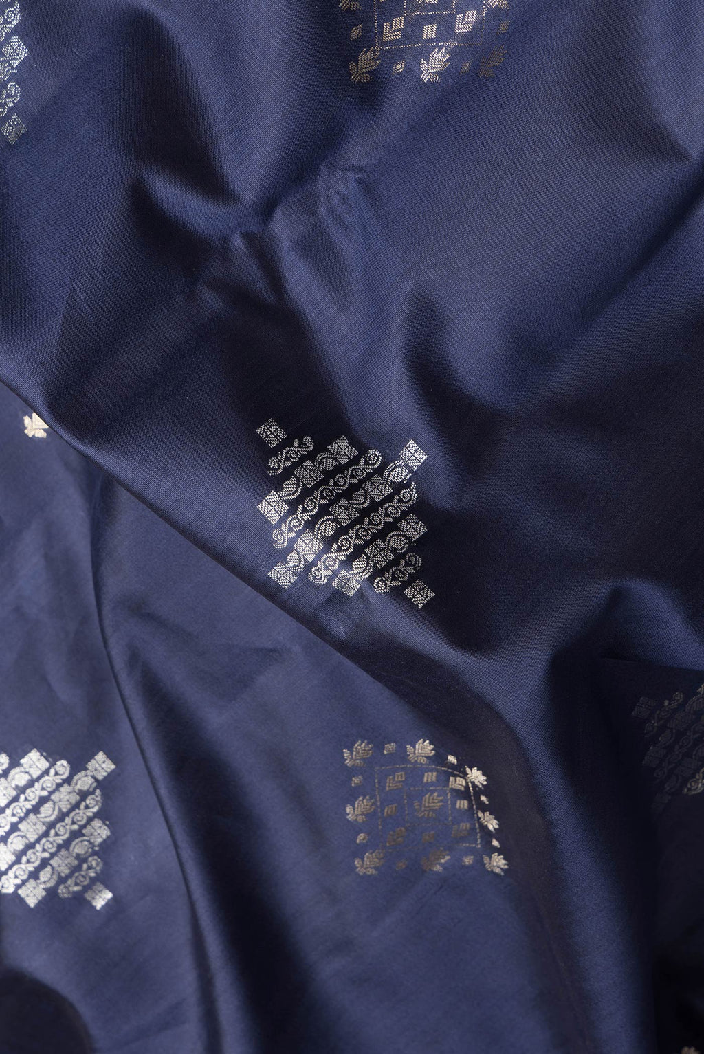 Close up of Navy Blue Dual Tone Tussar Silk Saree with Zari Butta on the body and Zari Border.  displaying folds