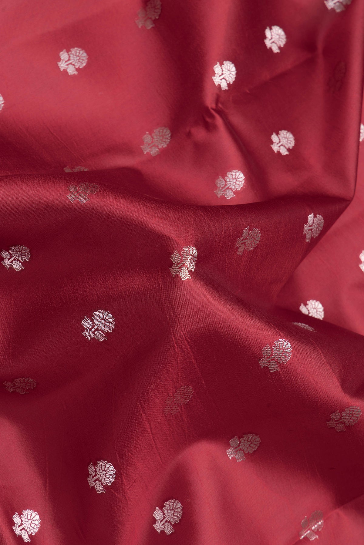 Close up of Maroon Dual Tone Banarasi Kota Silk Saree with Zari Butta on the body and Zari Border.  displaying folds