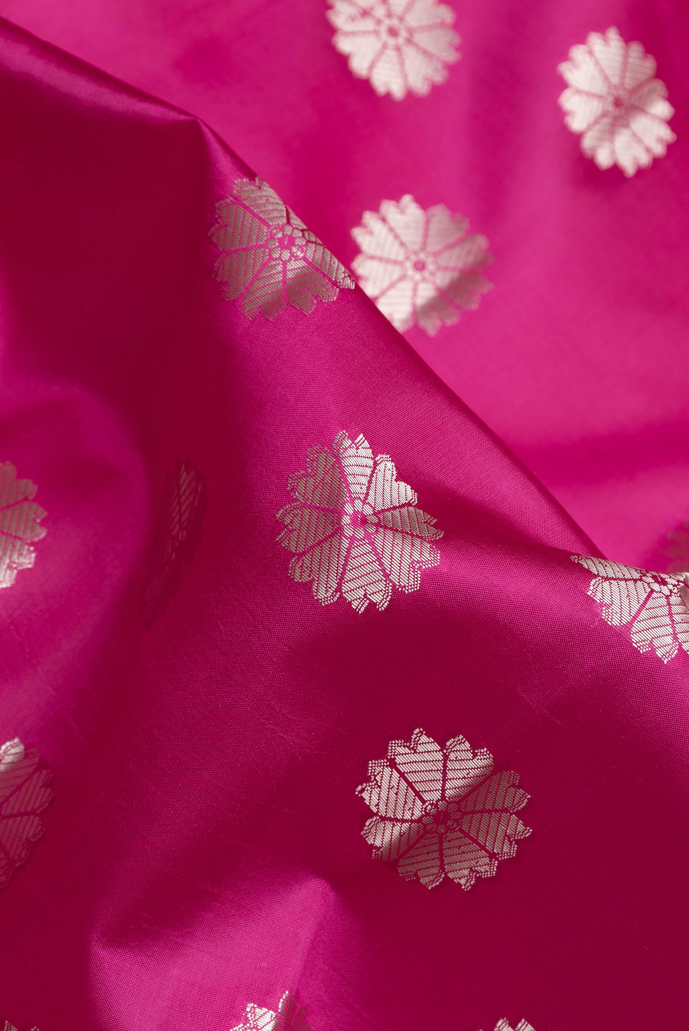 Close up of Pink Dual Tone Tussar Silk Saree with Zari Butta on the body and Zari Border.  displaying folds