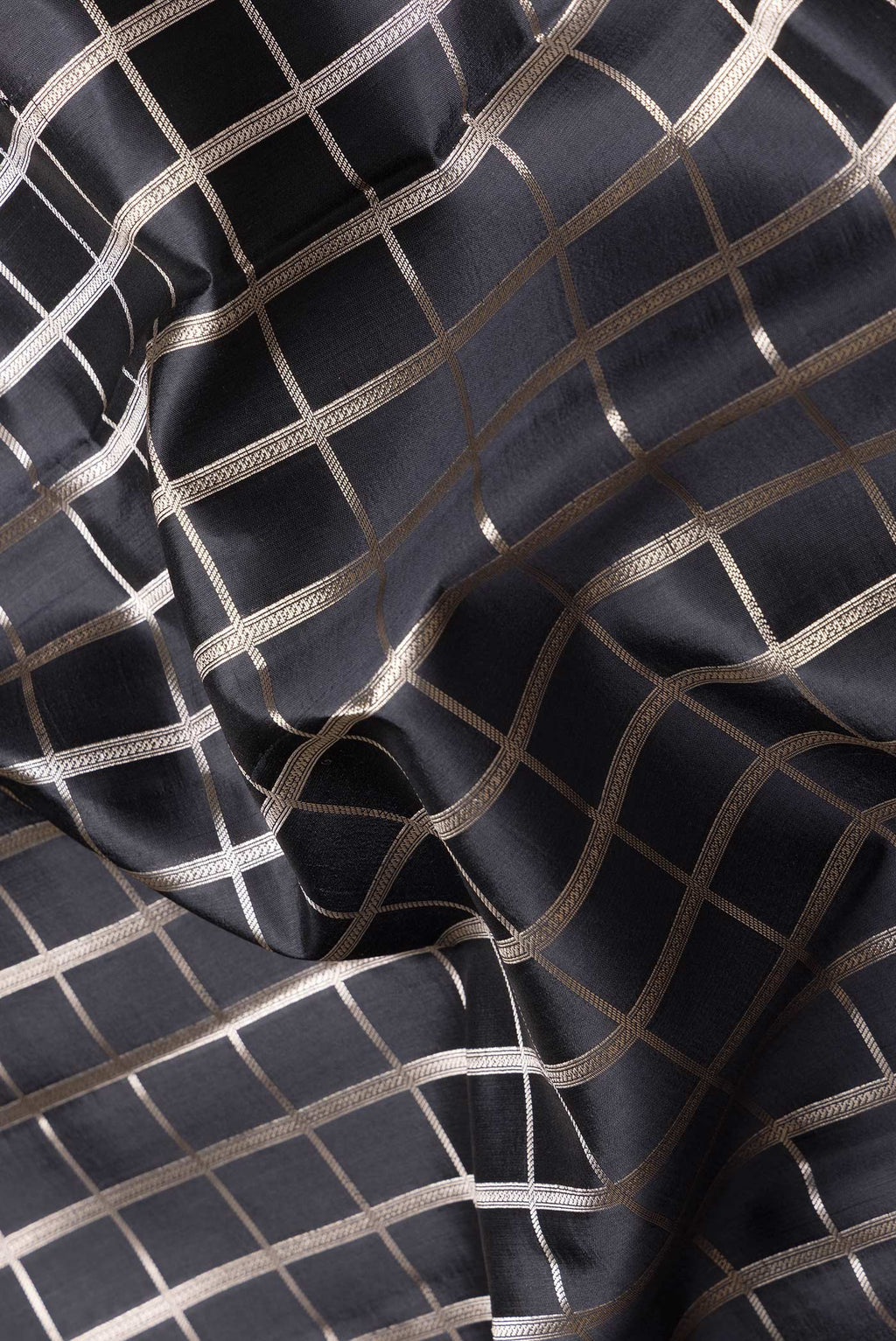 Close up of Black Dual Tone Tussar Silk Saree with Checked design on the body and Zari Border.  displaying folds