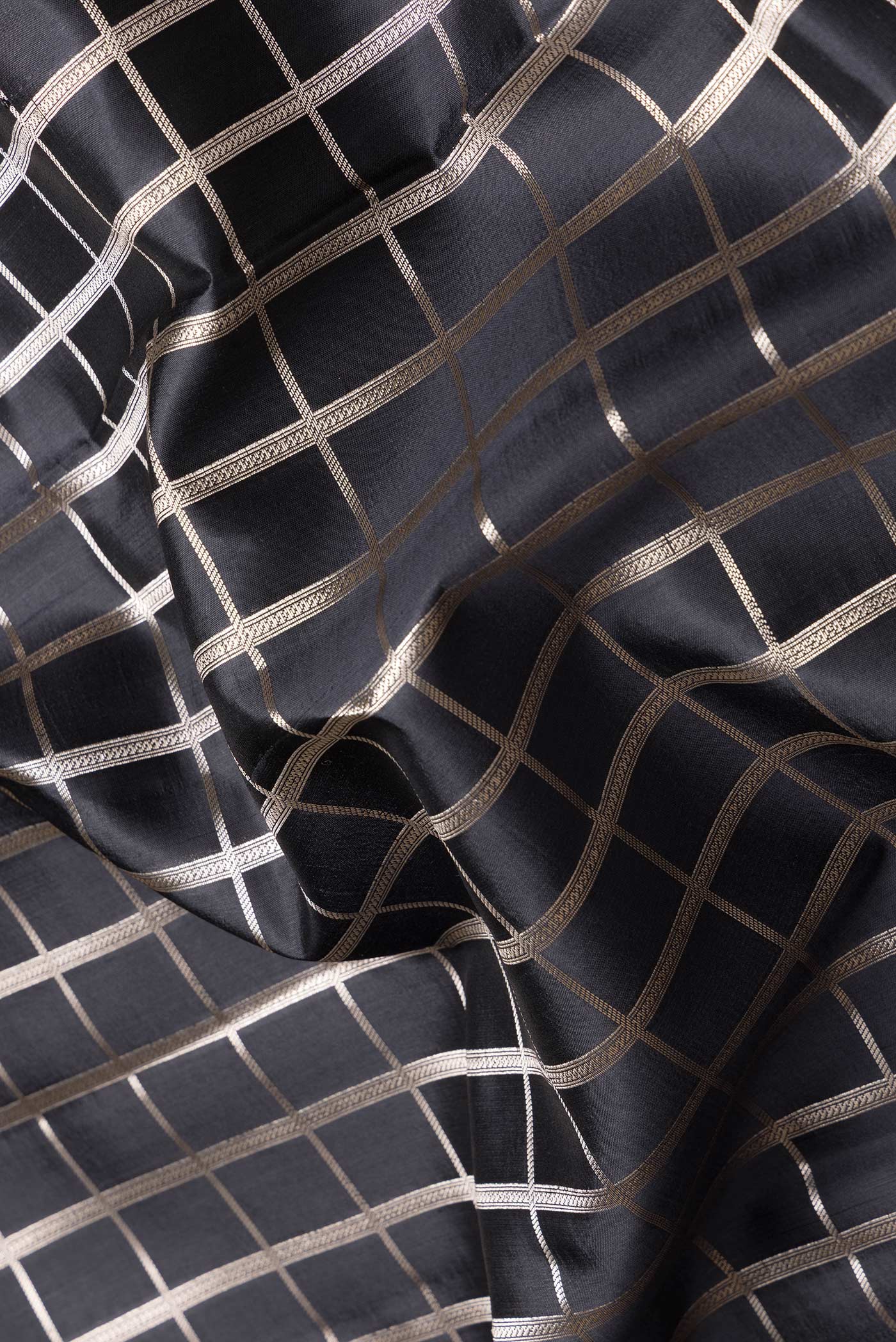Close up of Black Dual Tone Tussar Silk Saree with Checked design on the body and Zari Border.  displaying folds
