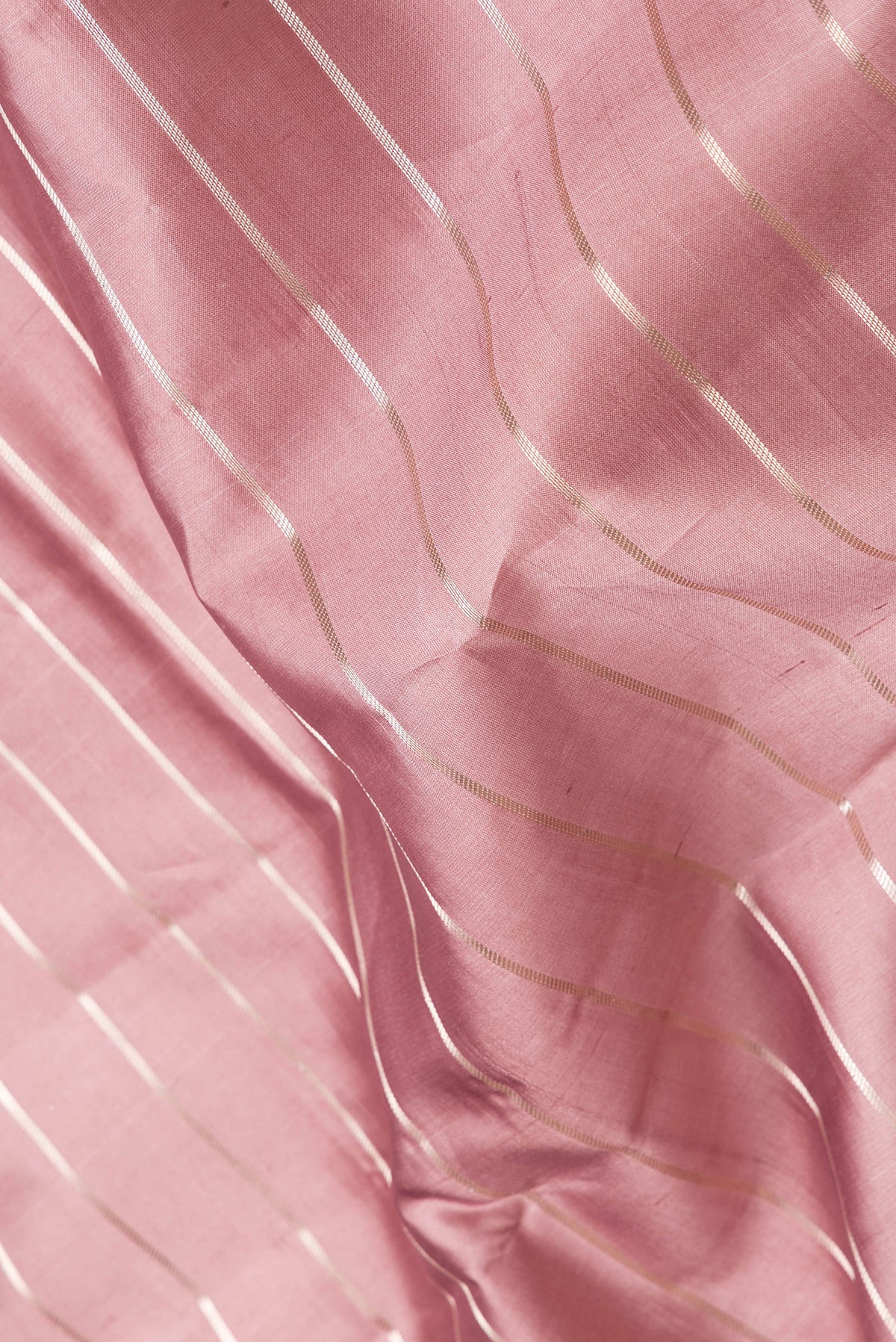 Close up of Rose Gold Dual Tone Tussar Silk Saree with Stripes on the body and Zari Border.  displaying folds