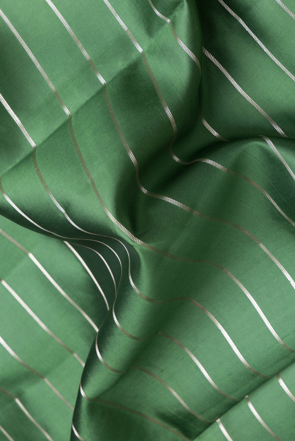 Close up of Green Dual Tone Tussar Silk Saree with Stripes on the body and Zari Border.  displaying folds