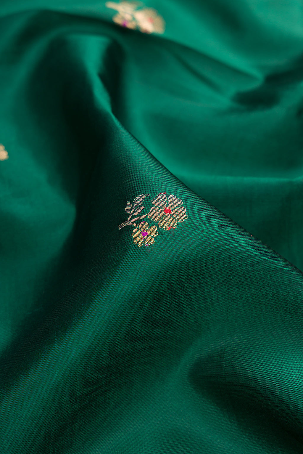 Close up of Bottle Green Dual Tone Tussar Silk Saree with Zari Butta on the body and Fancy Border.  displaying folds