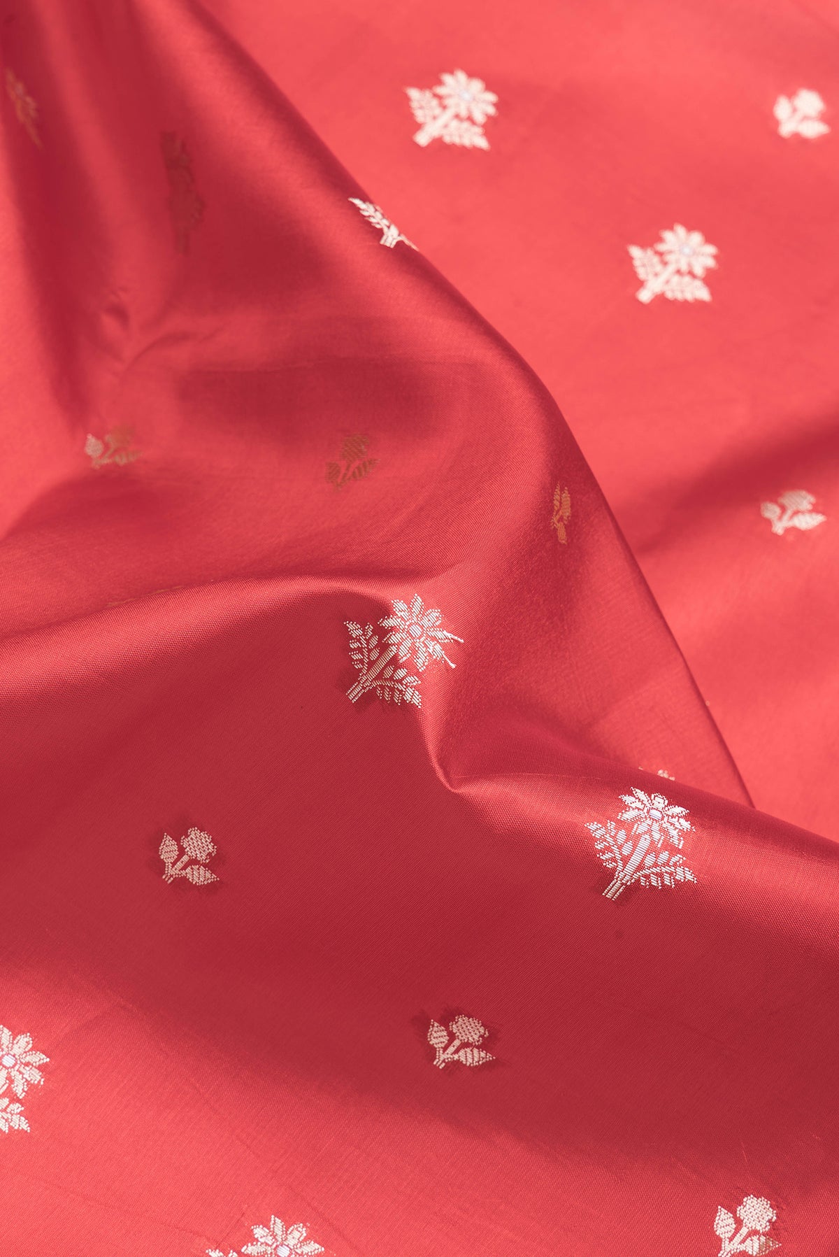 Close up of Red Dual Tone Banarasi Raw Silk Saree with Zari Butta on the body and Zari Border.  displaying folds
