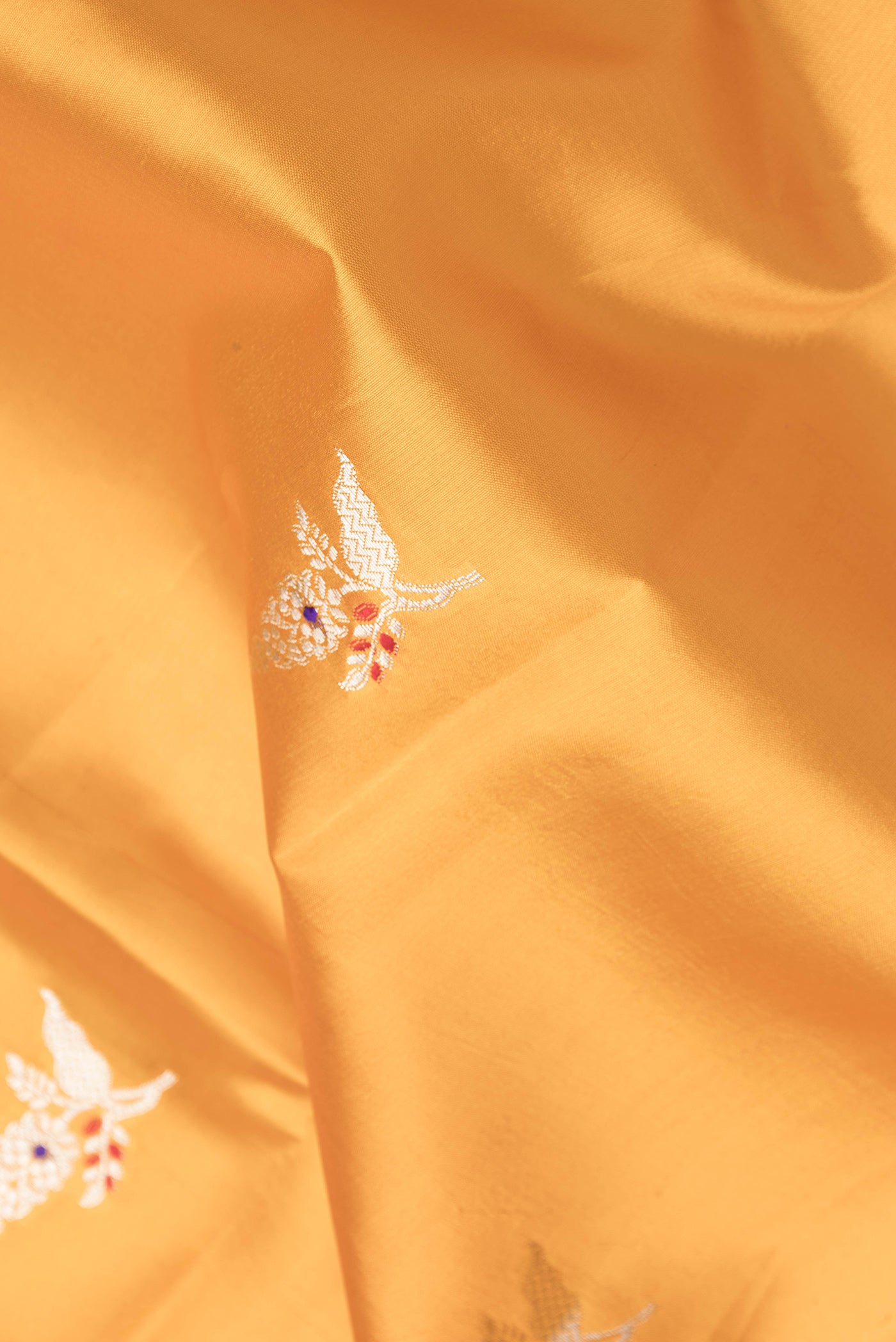 Close up of Mustard Dual Tone Tussar Silk Saree with Zari Butta on the body and Fancy Border.  displaying folds