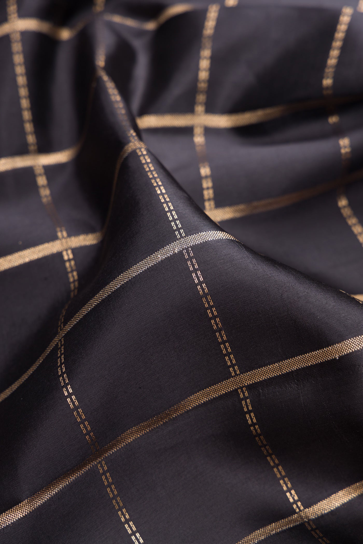 Close up of Black Dual Tone Tussar Silk Saree with Checked design on the body and Zari Border.  displaying folds