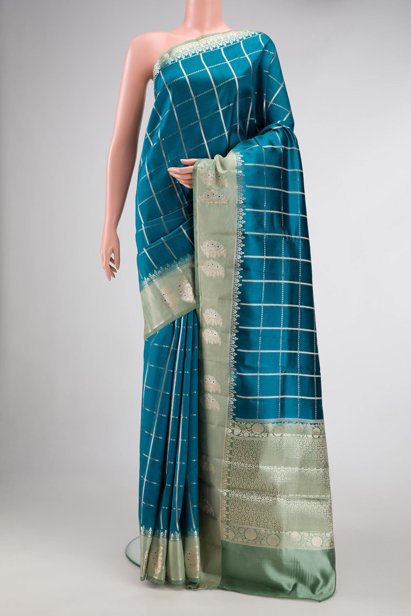 Peacock Blue Dual Tone Tussar Silk Saree with Checked design on the body and Zari Border.  displayed on a mannequin