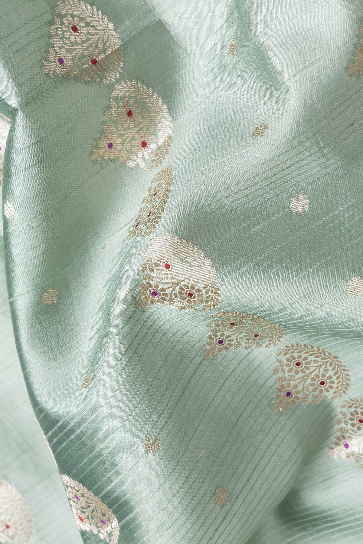 Close up of Sea Green Dual Tone Tussar Silk Saree with Zari And Thread Butta on the body and Zari Border.  displaying folds