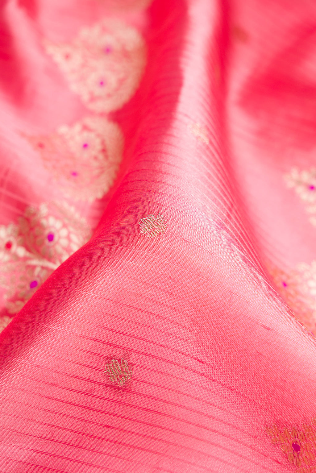 Close up of Pink Dual Tone Tussar Silk Saree with Zari Butta on the body and Fancy Border.  displaying folds