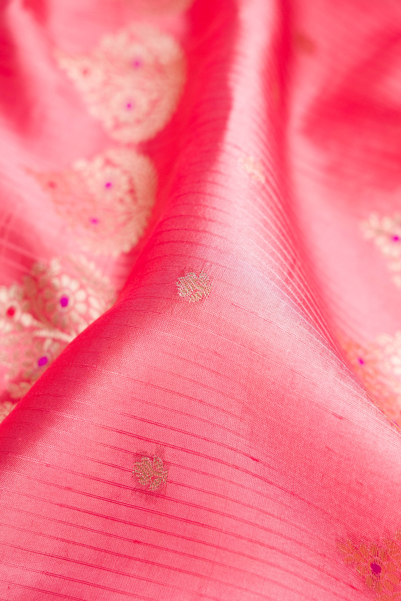 Close up of Pink Dual Tone Tussar Silk Saree with Zari Butta on the body and Fancy Border.  displaying folds