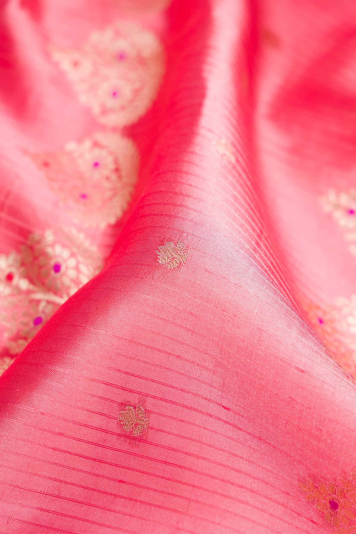Close up of Pink Dual Tone Tussar Silk Saree with Zari Butta on the body and Fancy Border.  displaying folds