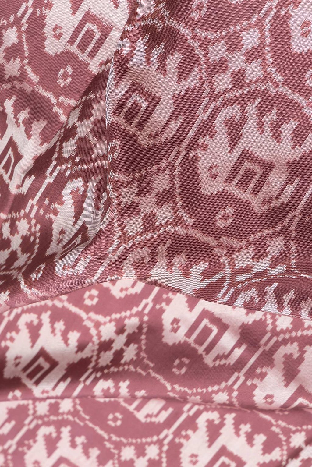 Close up of Brown Dual Tone Double Ikat Saree with Ikat Print on the body and Zari Border.  displaying folds