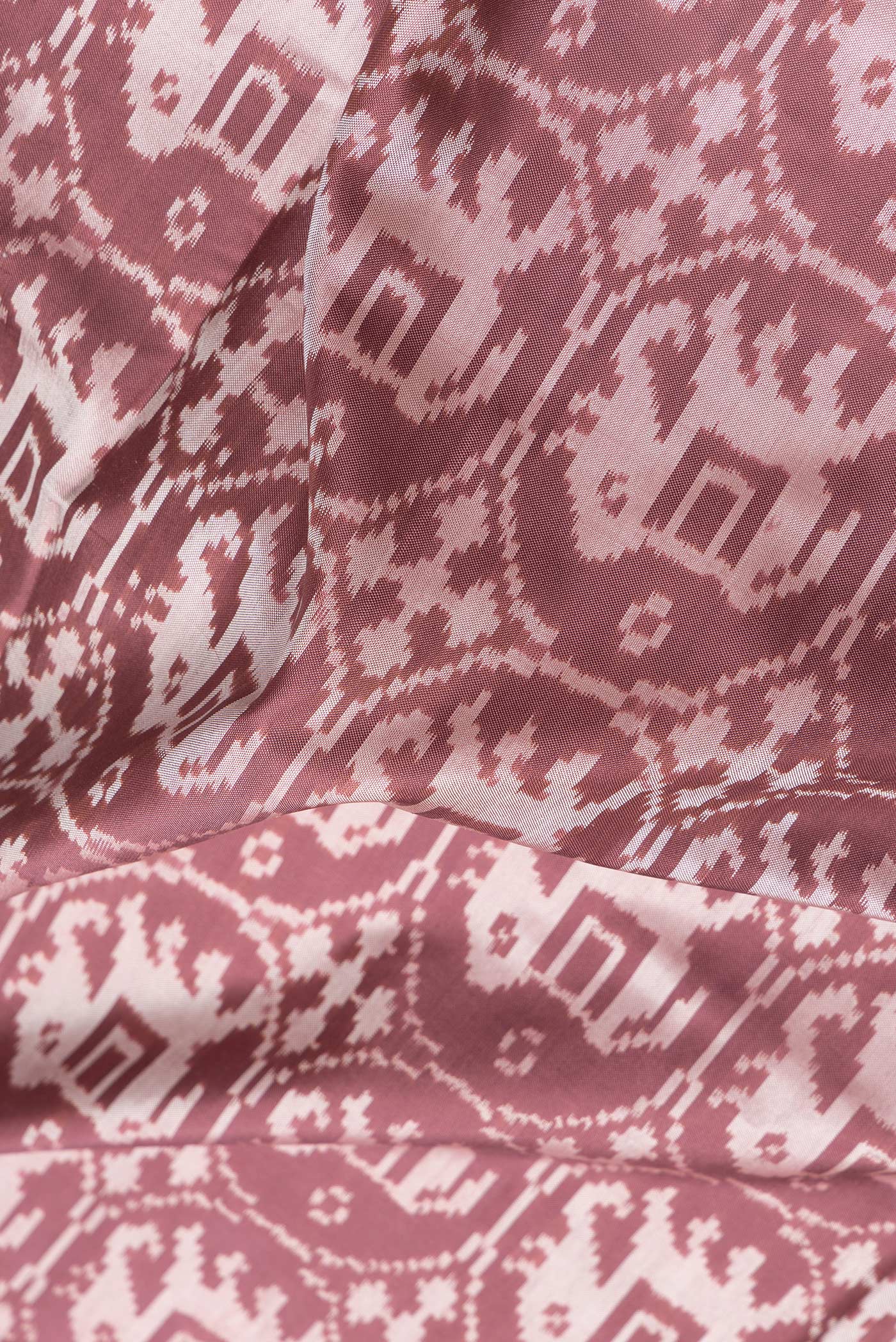 Close up of Brown Dual Tone Double Ikat Saree with Ikat Print on the body and Zari Border.  displaying folds