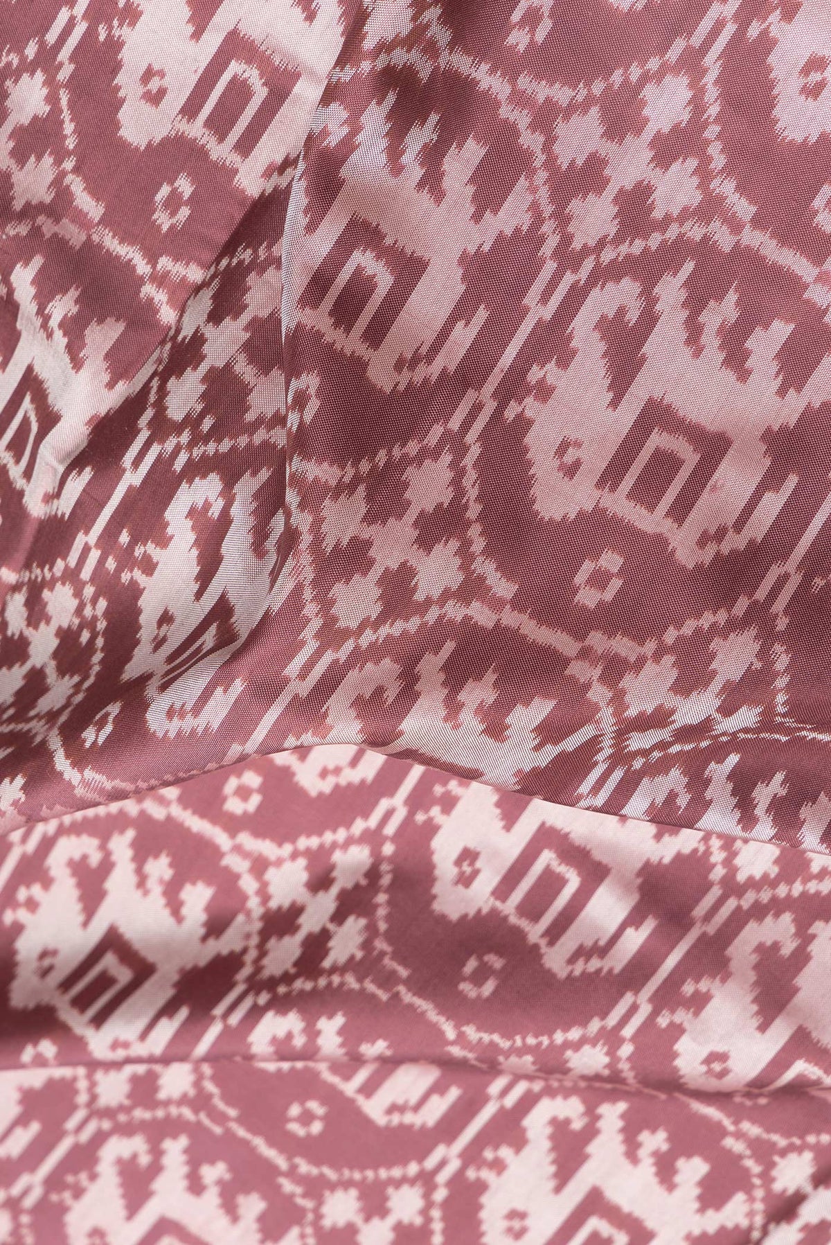Close up of Brown Dual Tone Double Ikat Saree with Ikat Print on the body and Zari Border.  displaying folds
