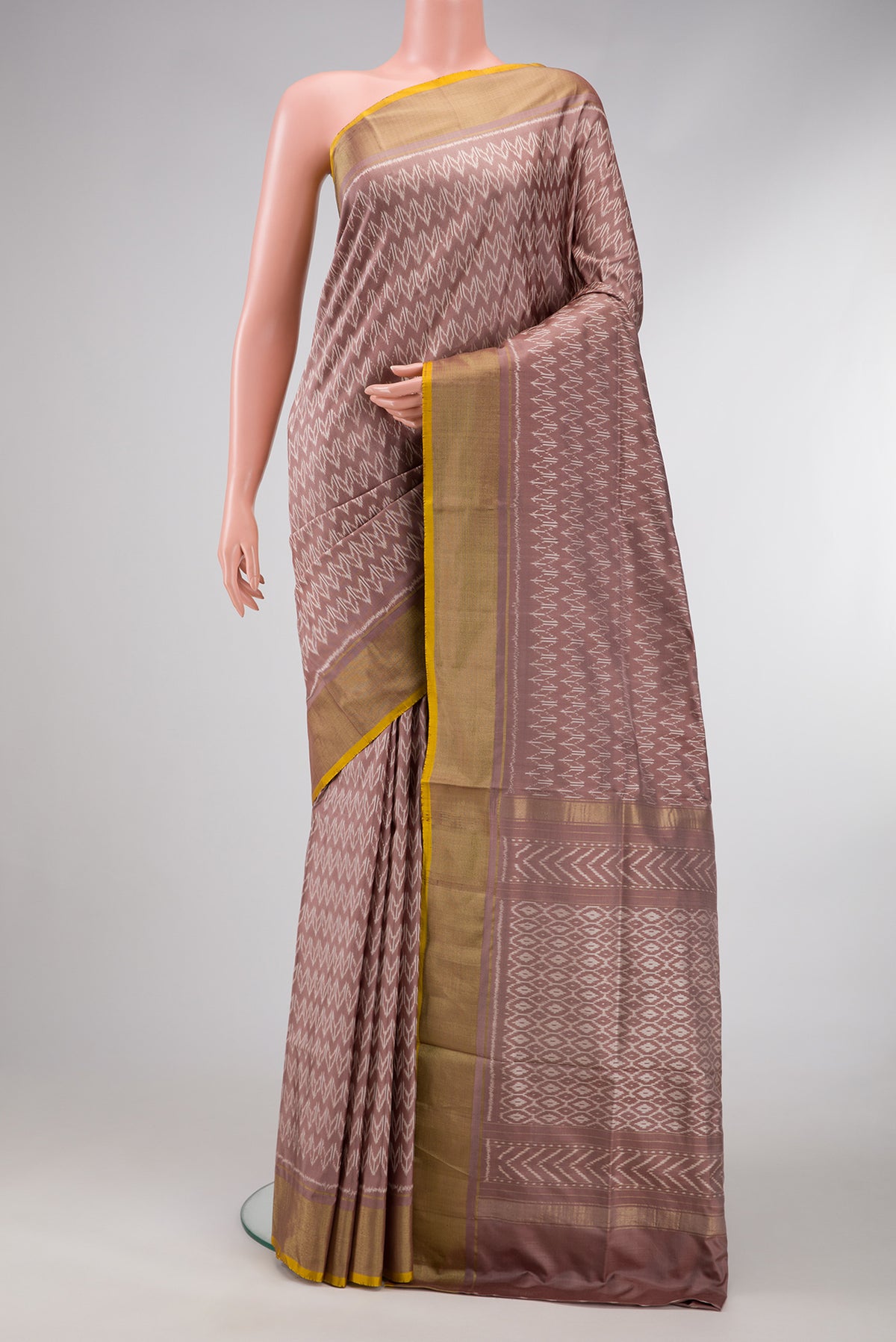 Brown Dual Tone Double Ikat Saree with Ikat Print on the body and Zari Border.  displayed on a mannequin