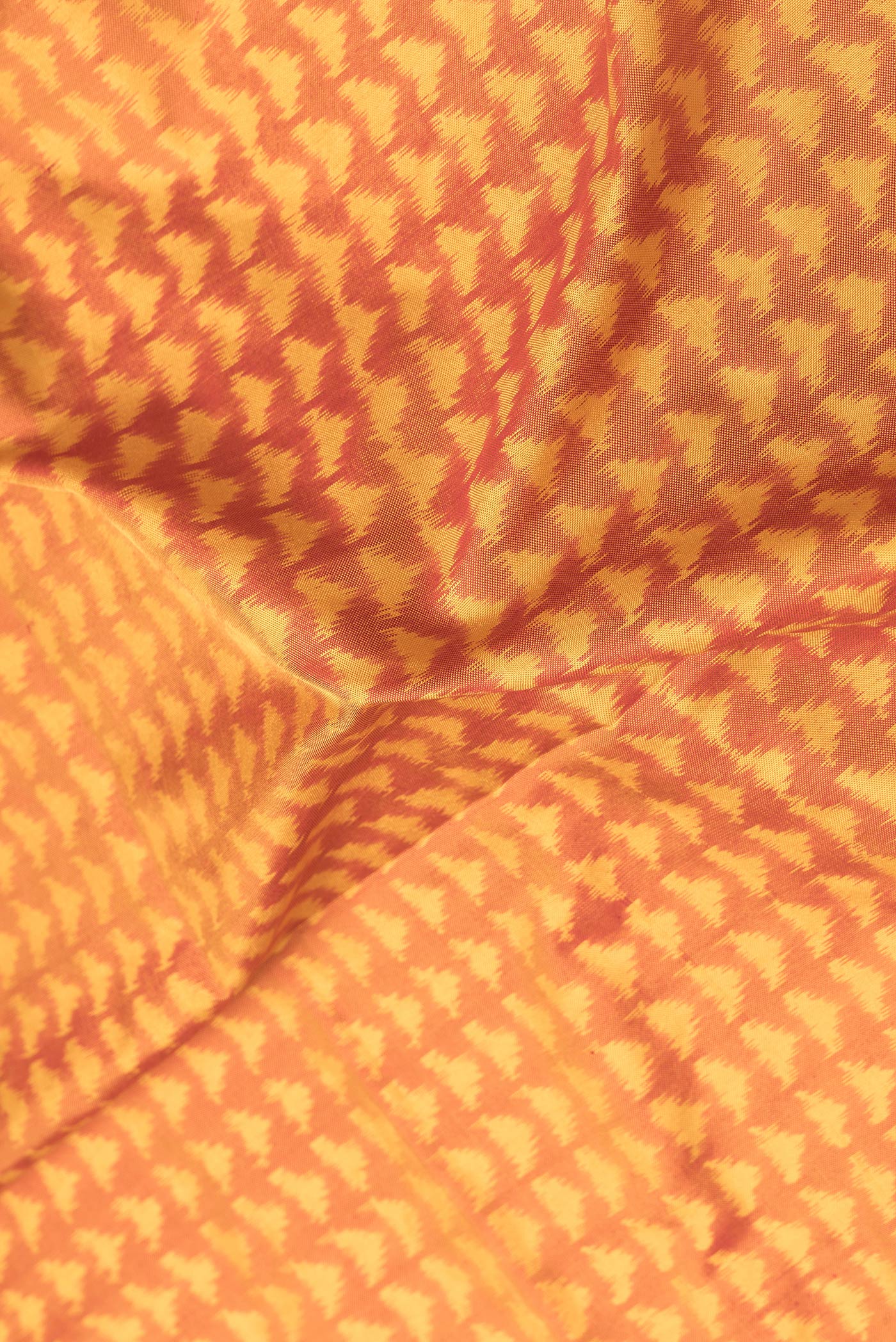 Close up of Mustard Dual Tone Double Ikat Saree with Ikat Print on the body and Plain Border.  displaying folds