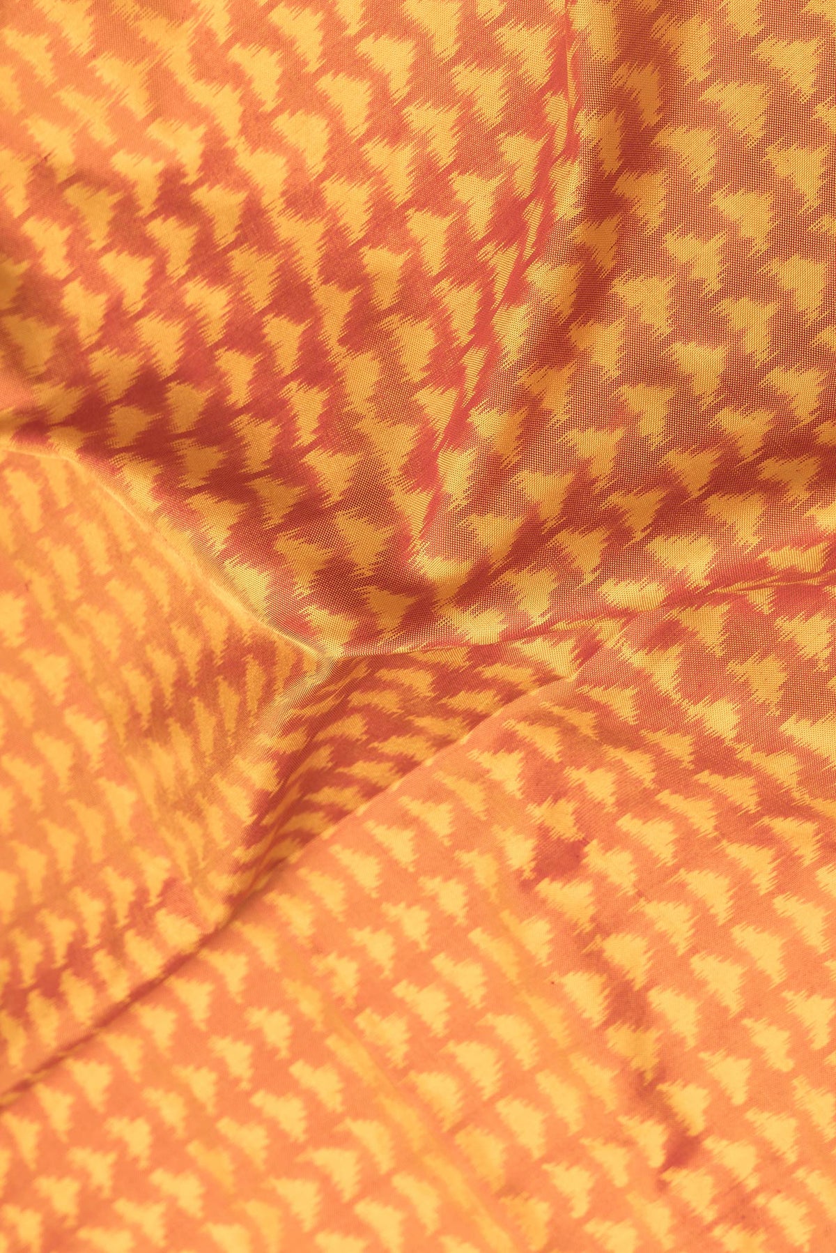 Close up of Mustard Dual Tone Double Ikat Saree with Ikat Print on the body and Plain Border.  displaying folds