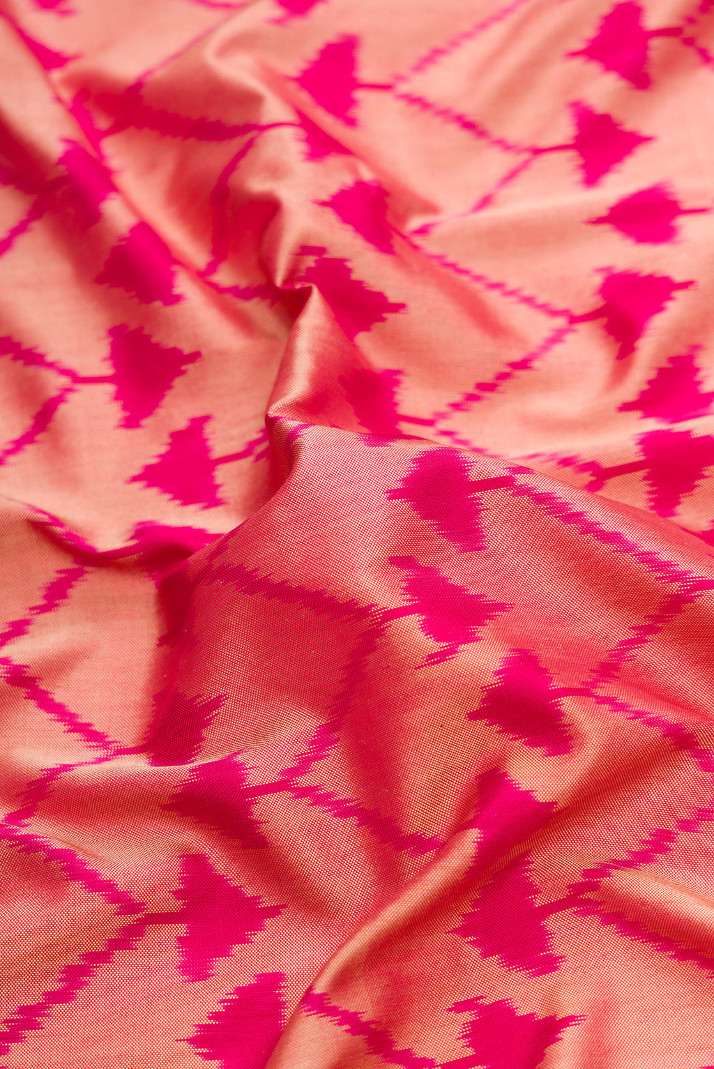 Close up of Pink Dual Tone Double Ikat Saree with Ikat Print on the body and Plain Border.  displaying folds